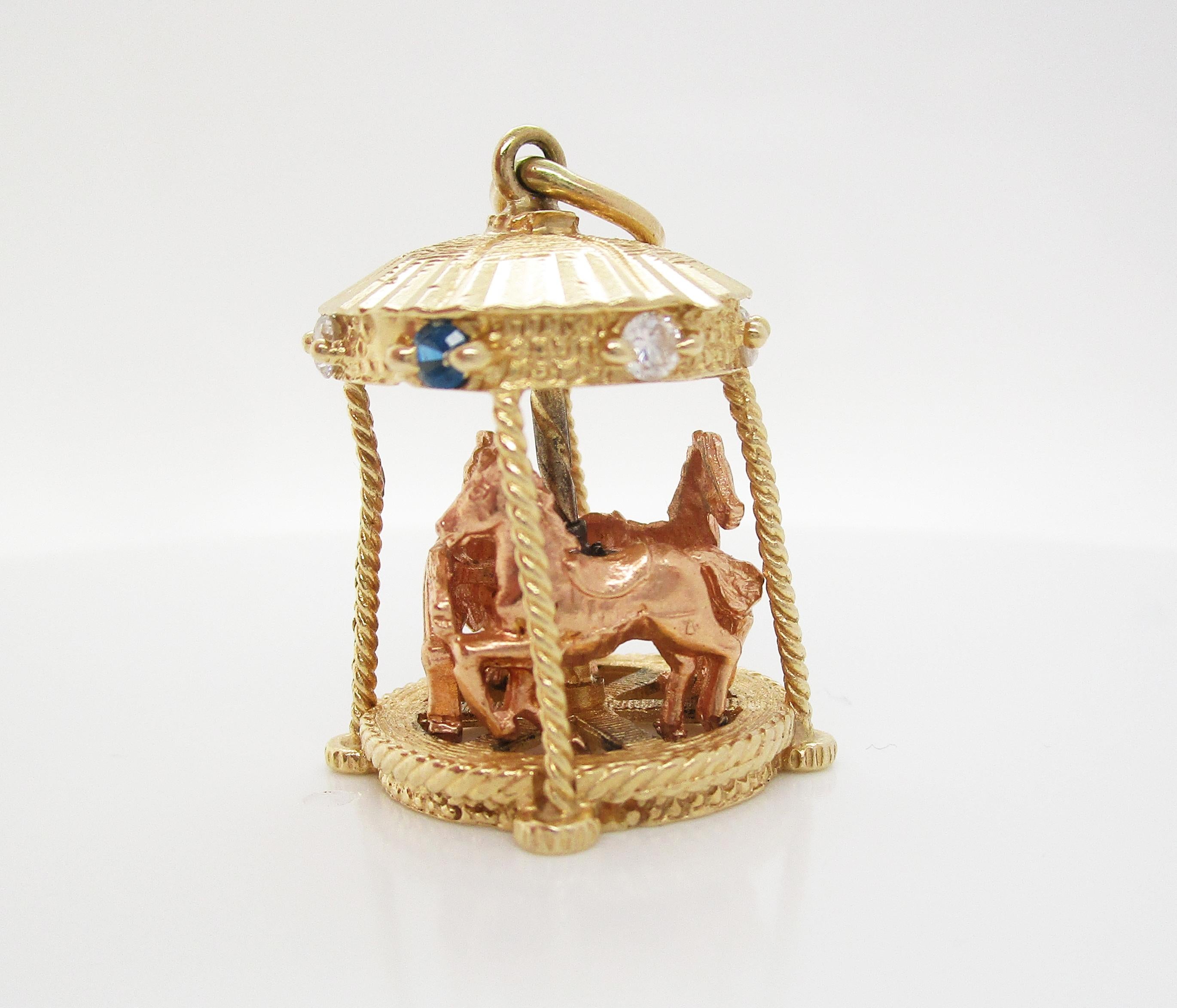 This incredible mid-century pendant is in 14k yellow gold and is an awesome moving carousel design! The carousel is all 14k yellow gold and features three rose gold horses that really move up, down, and around the carousel! The top of the carousel