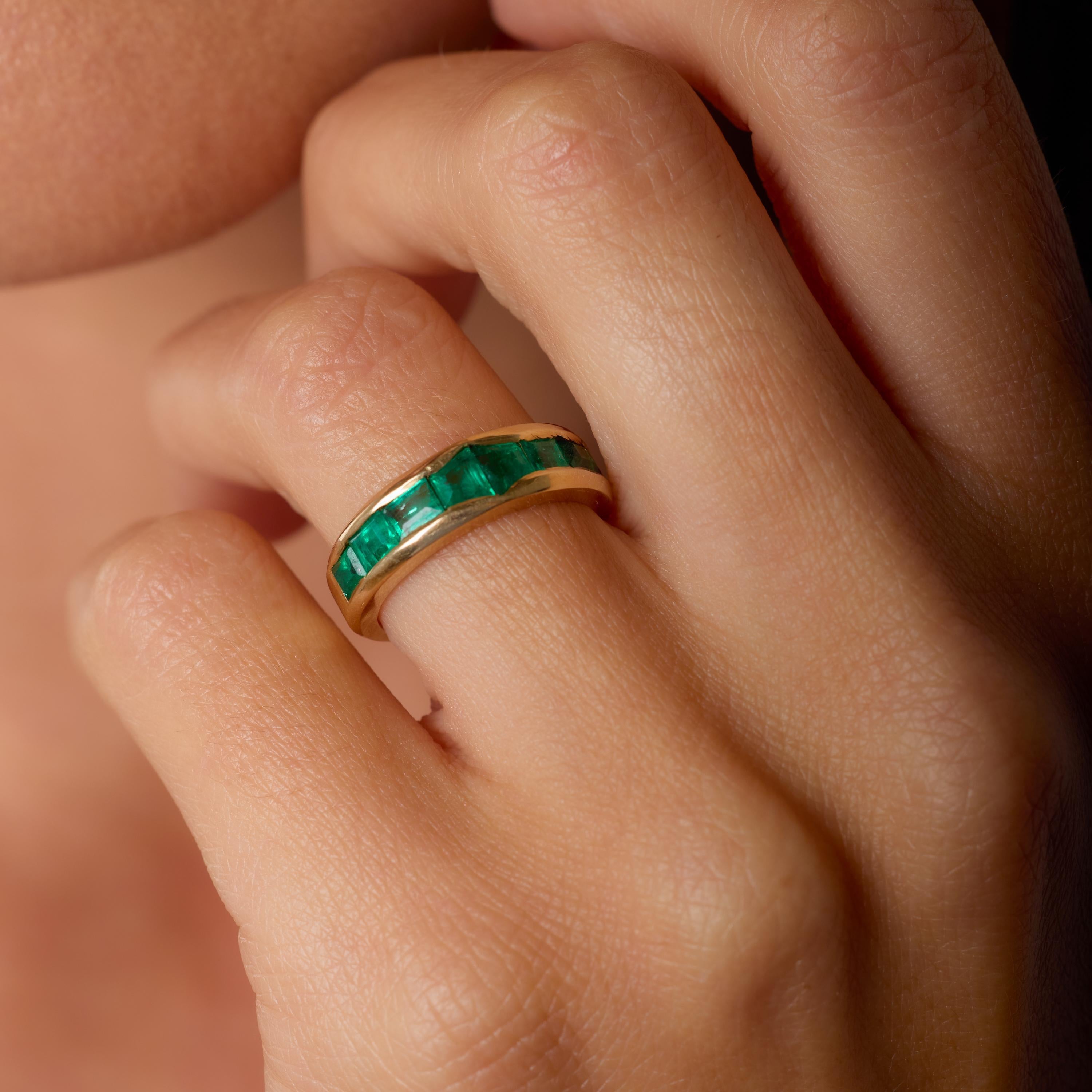 Este llamativo anillo de mediados de siglo muestra una vibrante disposición de ocho esmeraldas de talla cuadrada, que en total suman aproximadamente 1,50 quilates. Las esmeraldas forman una banda geométrica de intenso color verde, reflejo del estilo