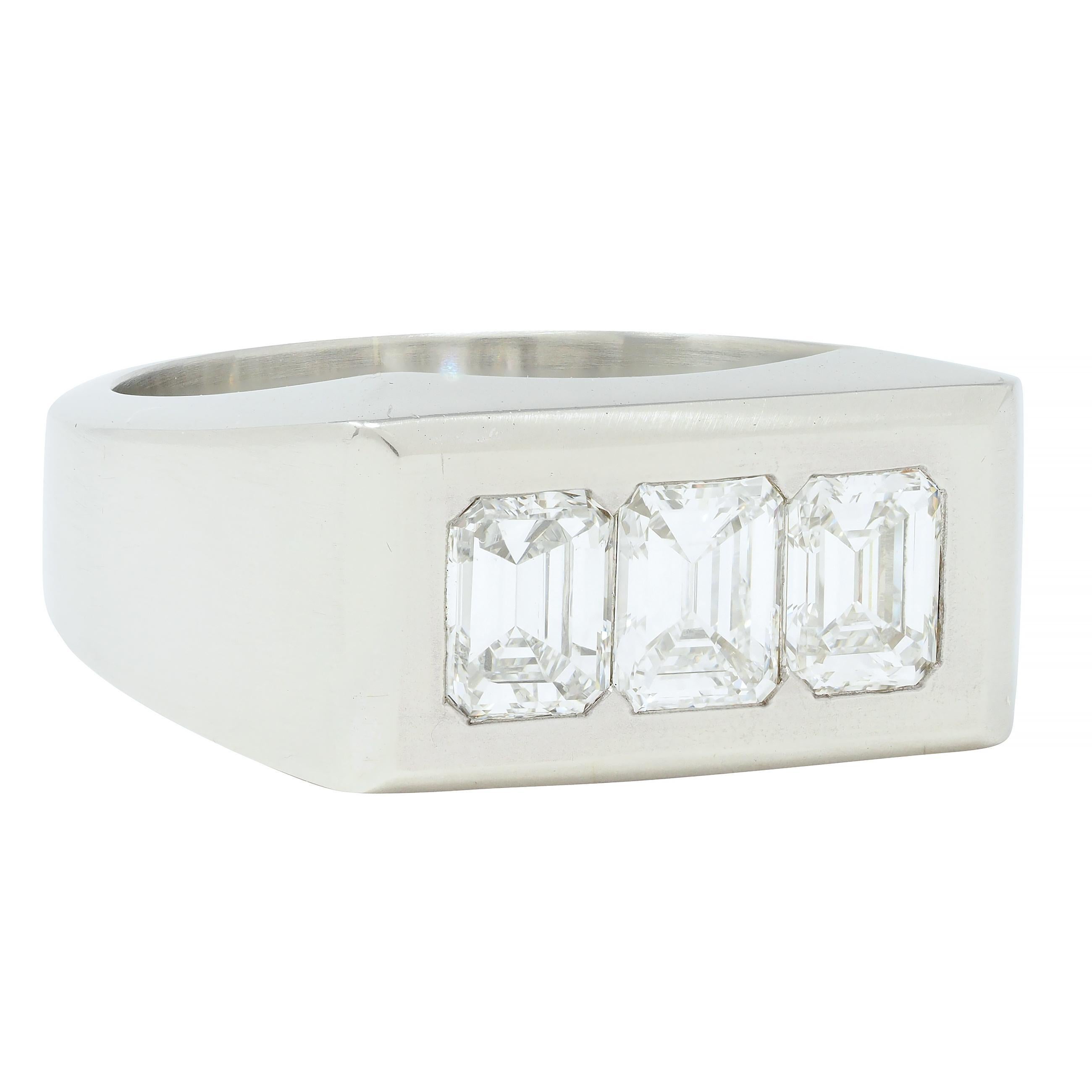 Centering three emerald cut diamonds weighing approximately 1.50 carats total 
F/G color with VS clarity - flush set to front
With high polished rectangular surround 
Stamped for 18 karat gold
With maker's mark
Circa: 1950s
Ring size: 8 and sizable