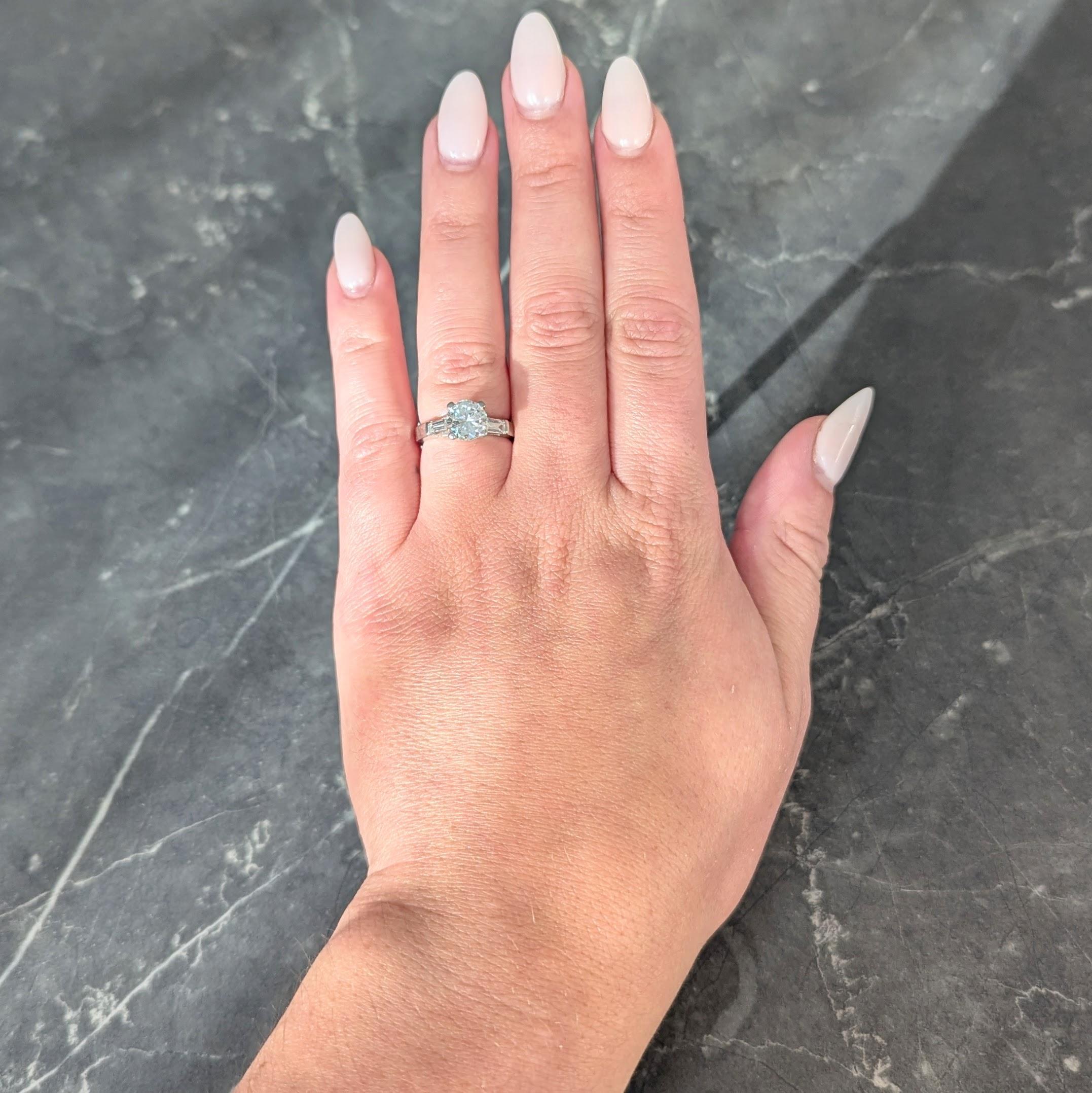 Centering a transitional cut diamond weighing approximately 1.31 carats - H color with SI1 clarity
Prong set in basket and flanked by cathedral shoulders bar set with diamonds
Tapered baguette cut and weighing in total 0.35 carat - G/H color with VS