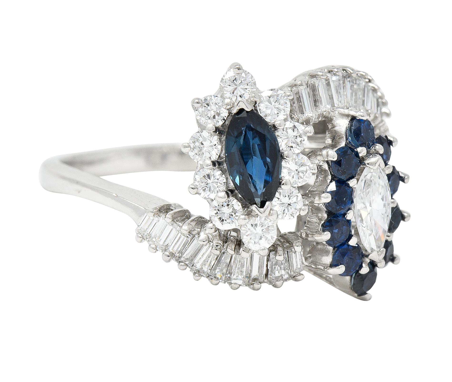 Designed as a bypass style ring terminating with prong set diamond and sapphire clusters, Once centering a sapphire and the other a diamond; both marquise cut. Sapphire weighs approximately 0.38 carat - transparent medium greenish-blue. Diamond