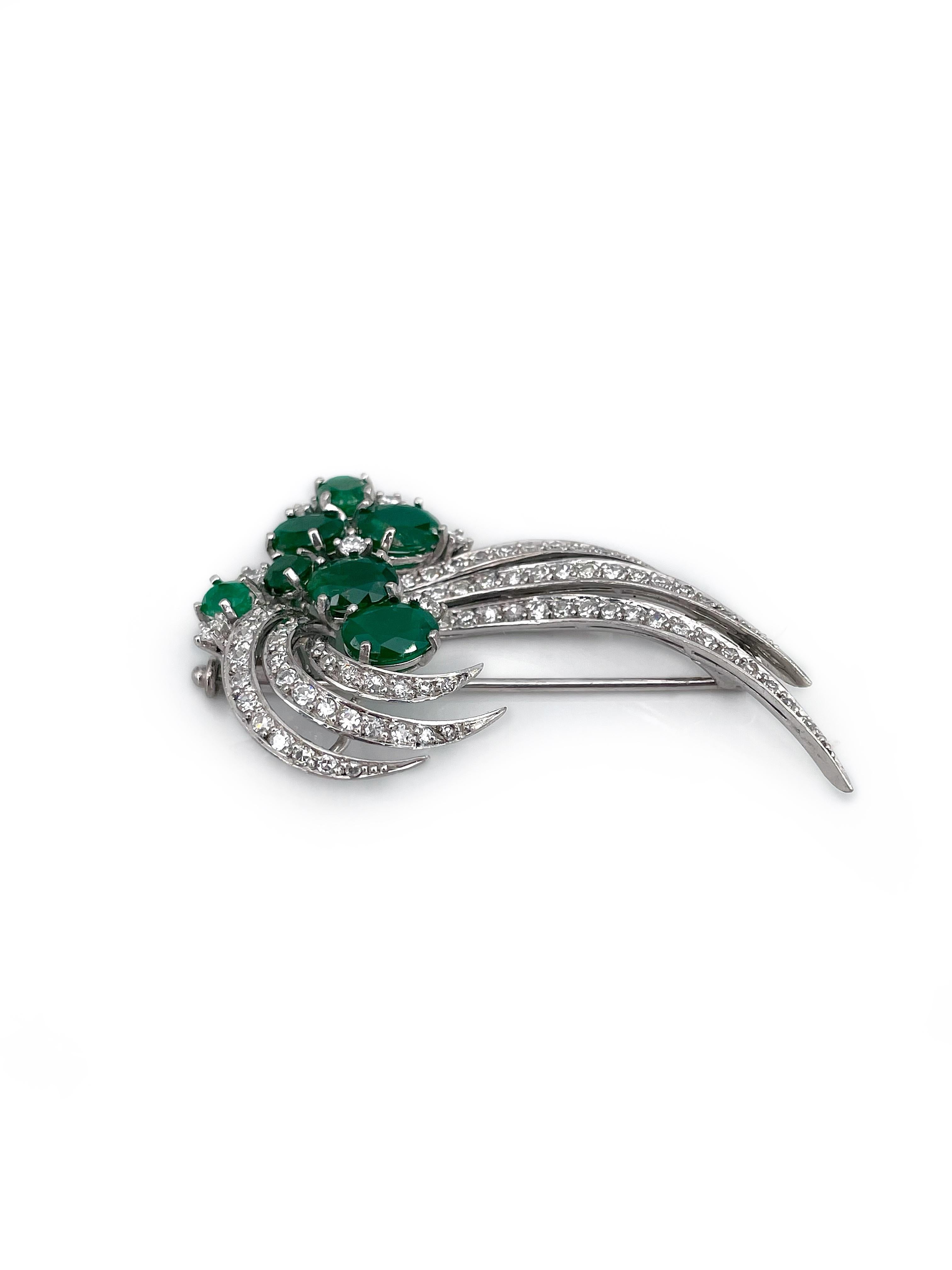 This is an elegant floral design pin brooch crafted in 18K white gold. The piece features 6 oval and 1 round shape rich green colour emeralds: TW 5.24ct, F. The gems are accompanied with 6 brilliant cut and 73 single cut diamonds: TW 1.365ct, W-STW,