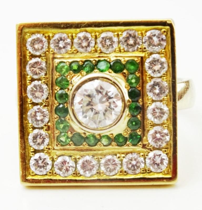 A designed ring probably from the 1960's or 70's.
The face of the ring is a square which in the middle sits a 5.3 mm round Diamond , H color , Vs2 clarity , .55ct weight.
It is surrounded by 20 0.015 point emeralds , total emerald weight , 30