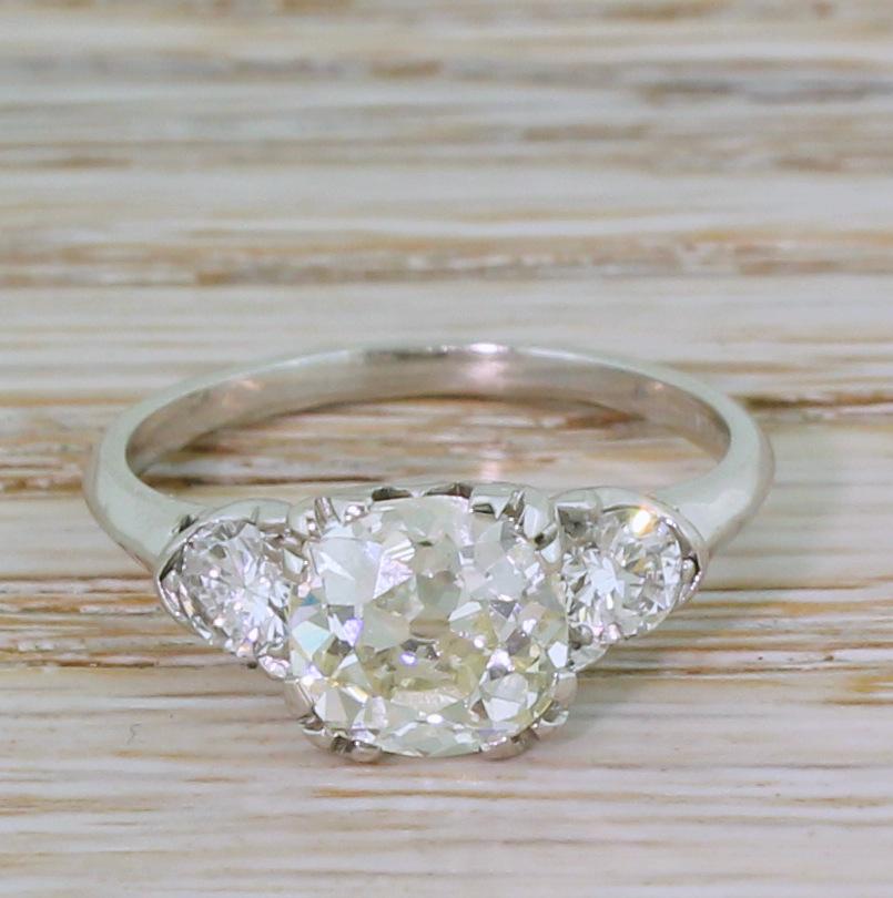 An utterly fabulous vintage diamond ring. The old mine cut diamond in the centre – graded by HRD Antwerp as M colour, VVS2 clarity – is internally clean and decidedly lively. The stone exhibits a light champagne hue which is emphasised by the pair