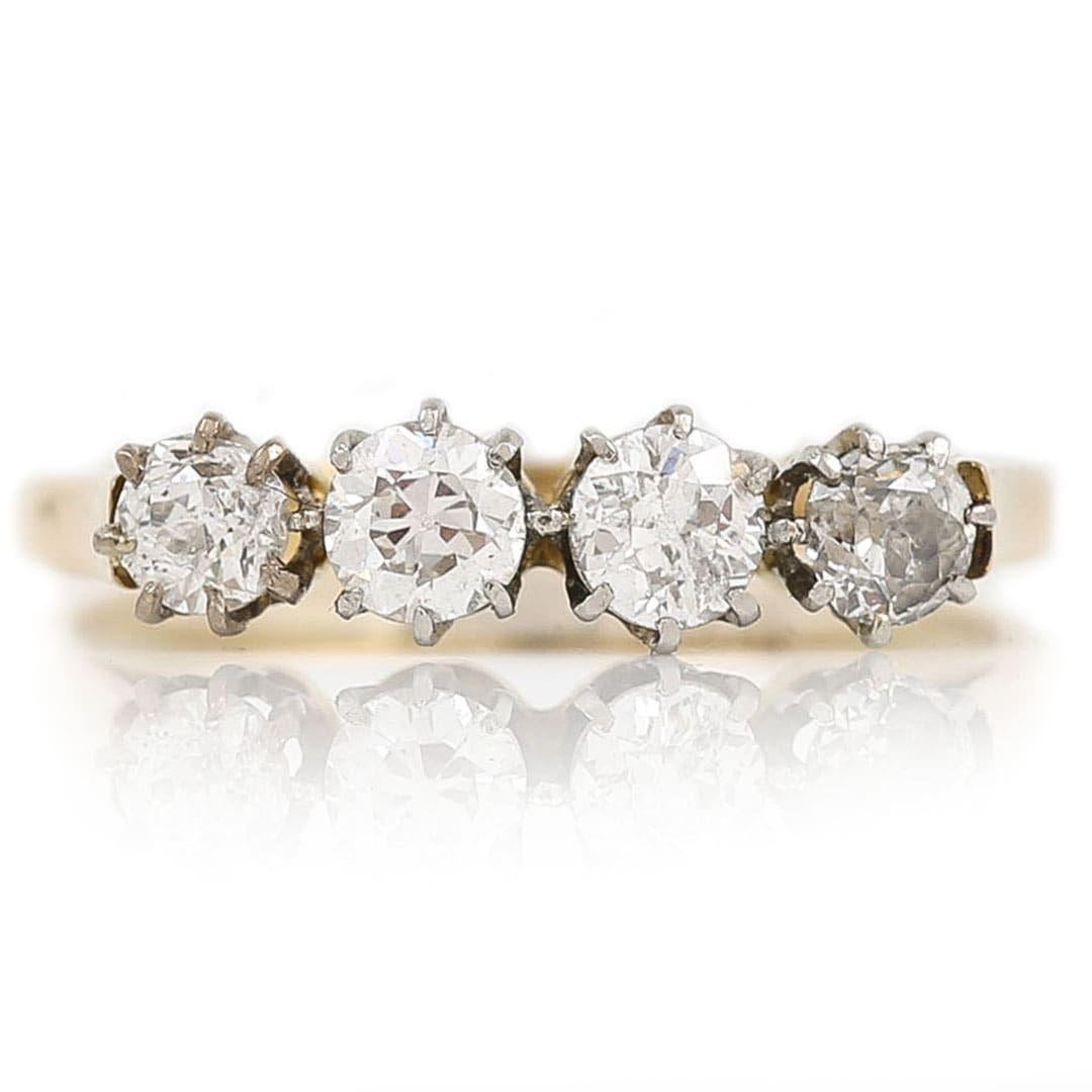 A striking mid-century 18ct gold and platinum mounted four stone diamond ring. The ring is made up of four Old Cut diamonds, estimated at 0.60ct traditionally set in a coronet setting the ring shows little wear, it should give good wearing ability
