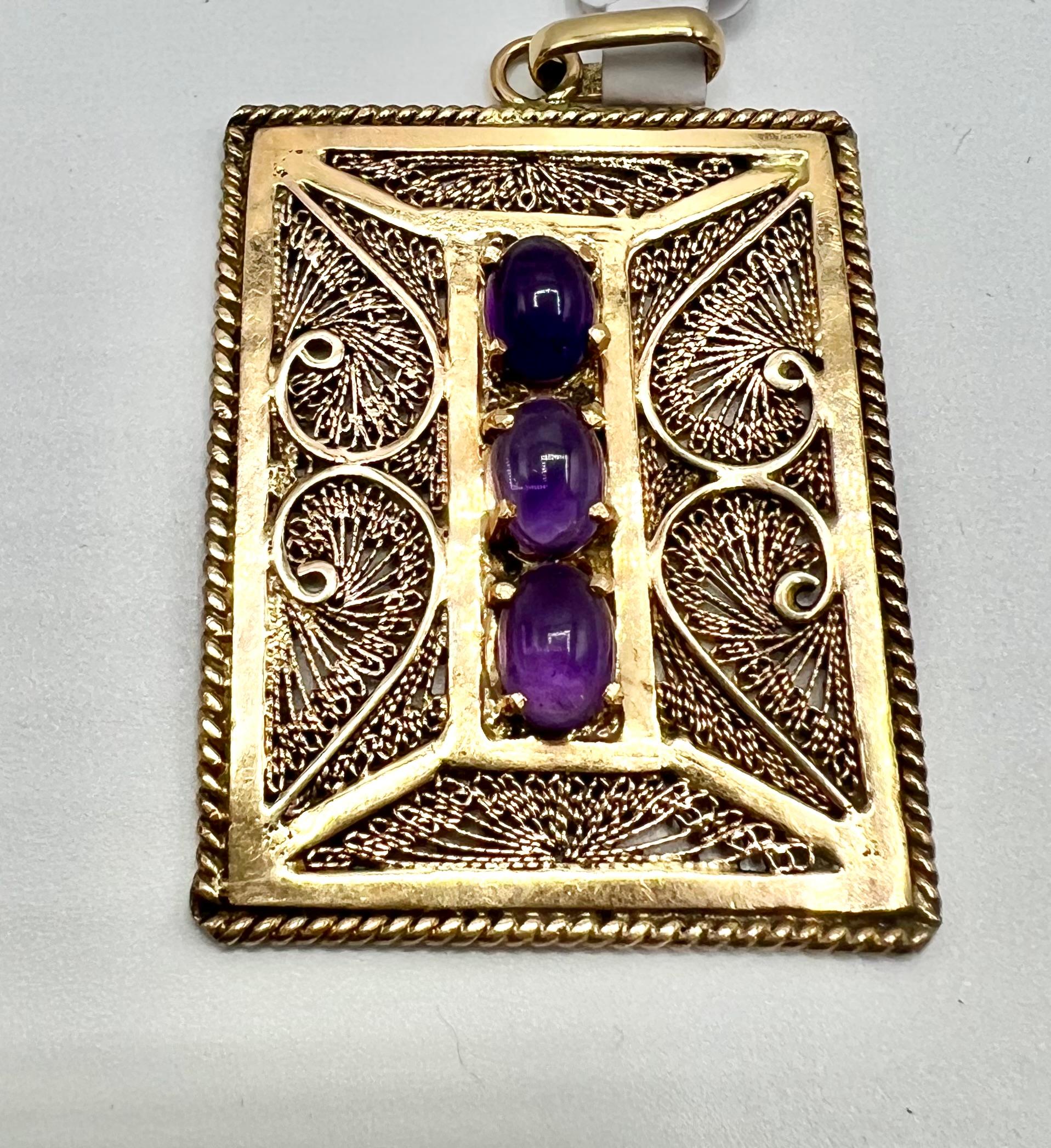 A rare and radiant piece of mid-century jewelry, this rectangular 18K gold pendant features a beautifully executed filigree design, entirely handcrafted, and likely created in the 1950s–1960s.

Set with three luminous cabochon-cut amethysts (each