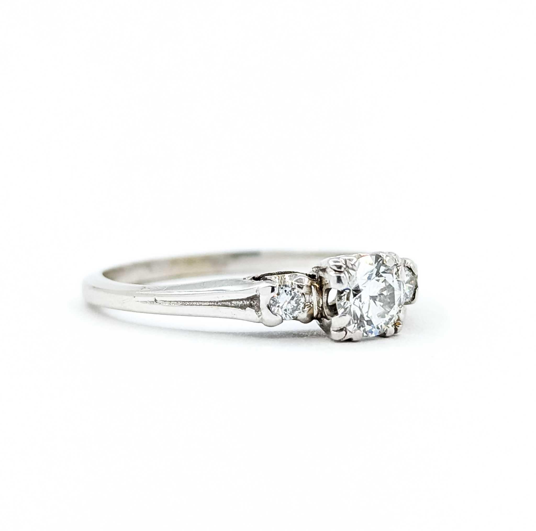 Questo affascinante anello Mid-Century è realizzato in oro bianco 18 carati e presenta un trio di scintillanti diamanti rotondi per un totale di 0,37 carati. Il diamante centrale è accentuato da due pietre laterali, creando un classico design a tre