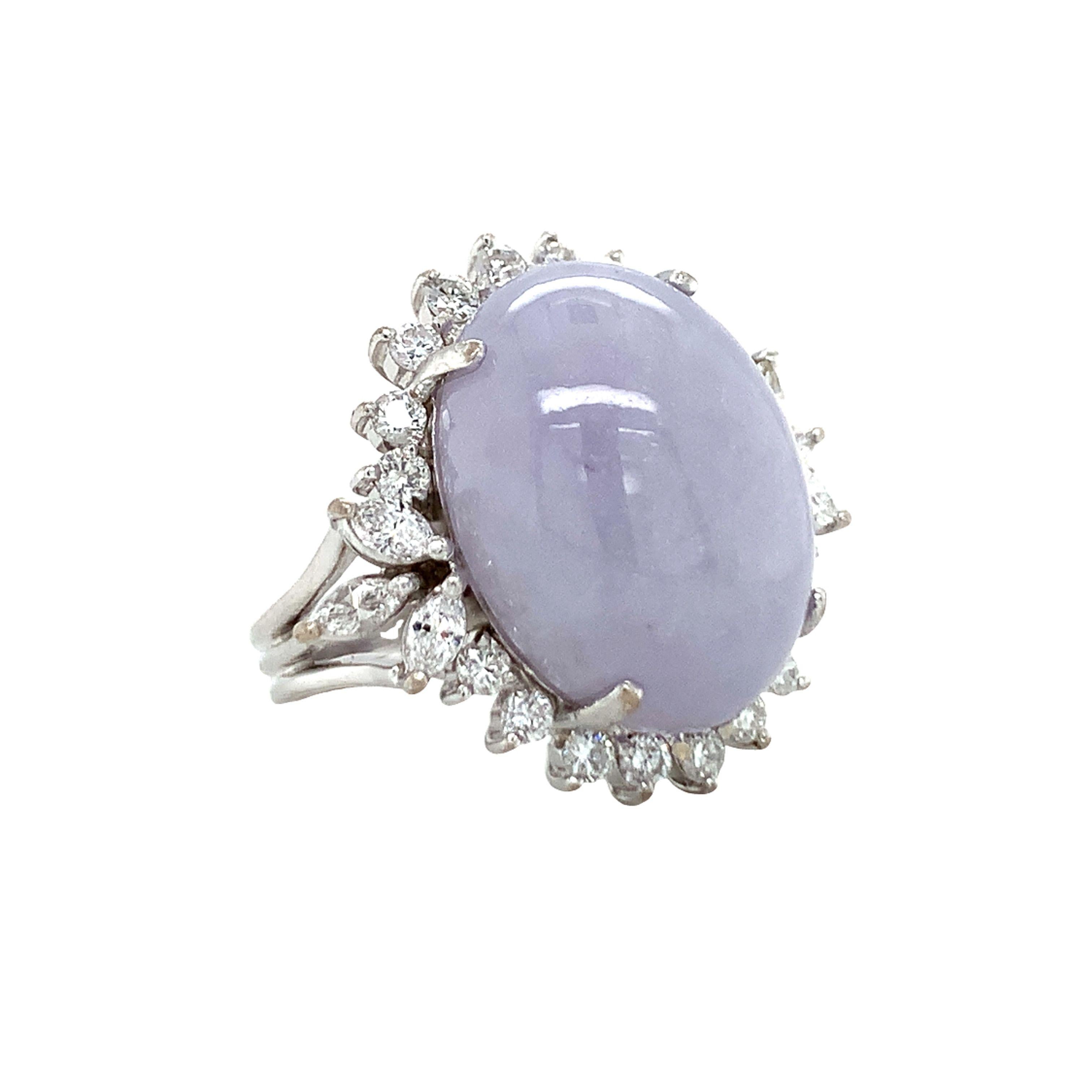 One mid-century lavender jade and diamond ring in 18k white gold centering one oval cabochon jade weighing 18 ct. (measures 19 x 15 x 7.5 millimeters) surrounded by 24 prong set, marquise and round brilliant cut diamonds weighing a total of 0.52 ct.
