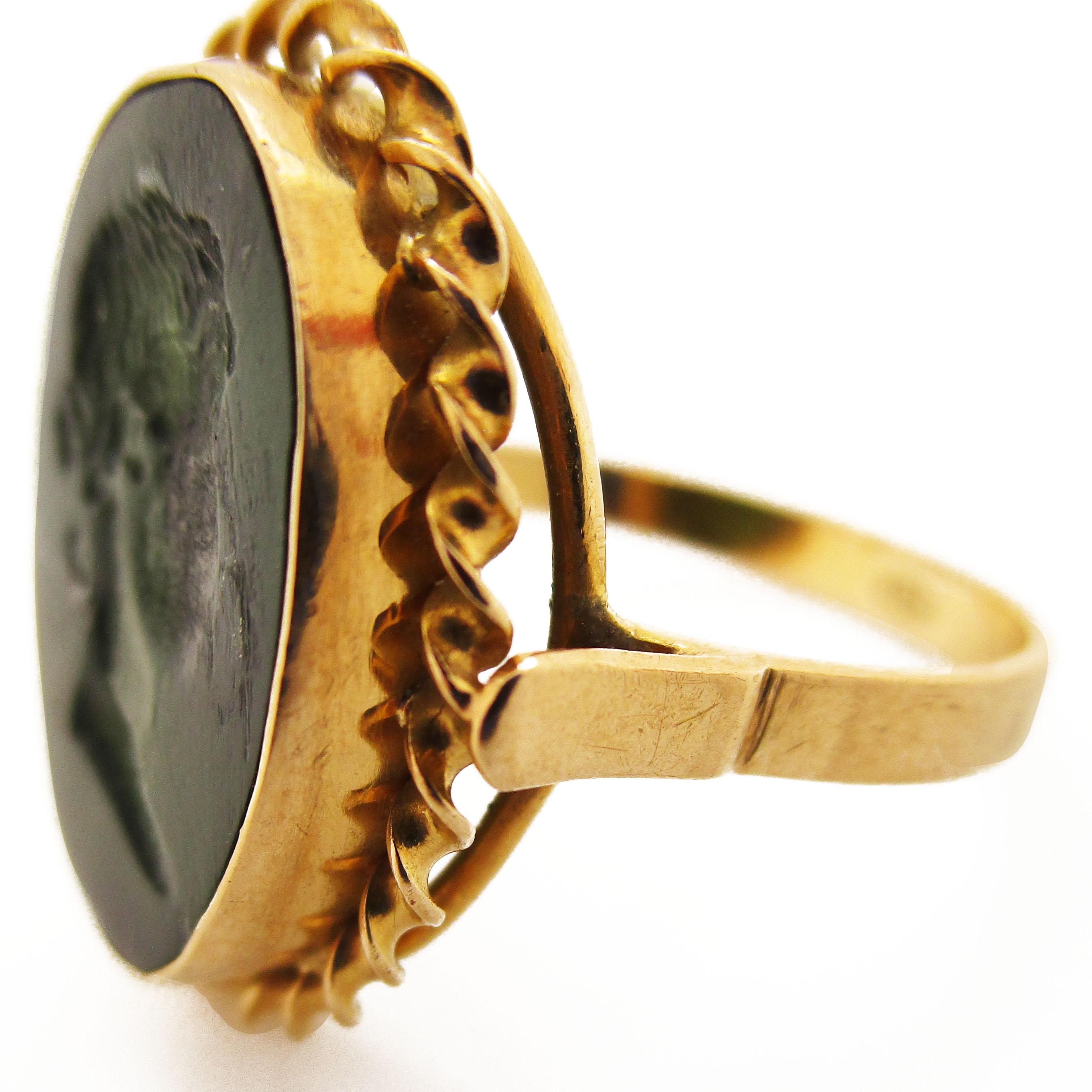 This is an amazing original hand-carved serpentine intaglio ring! The ring is 18 karat yellow gold, with a gorgeous twisted detailing framing the carved serpentine centerpiece. The serpentine is deep green in color and in great shape. The