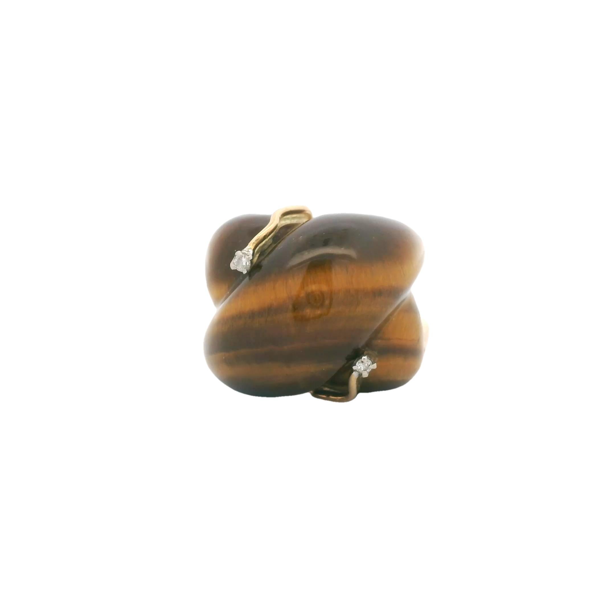 Una dichiarazione scultorea dell'epoca del Mid-Century, questo anello presenta uno splendido cabochon di occhio di tigre intagliato a forma di pan di zenzero incastonato in oro giallo 18 carati. La ricca pietra marrone dorato è impreziosita da due