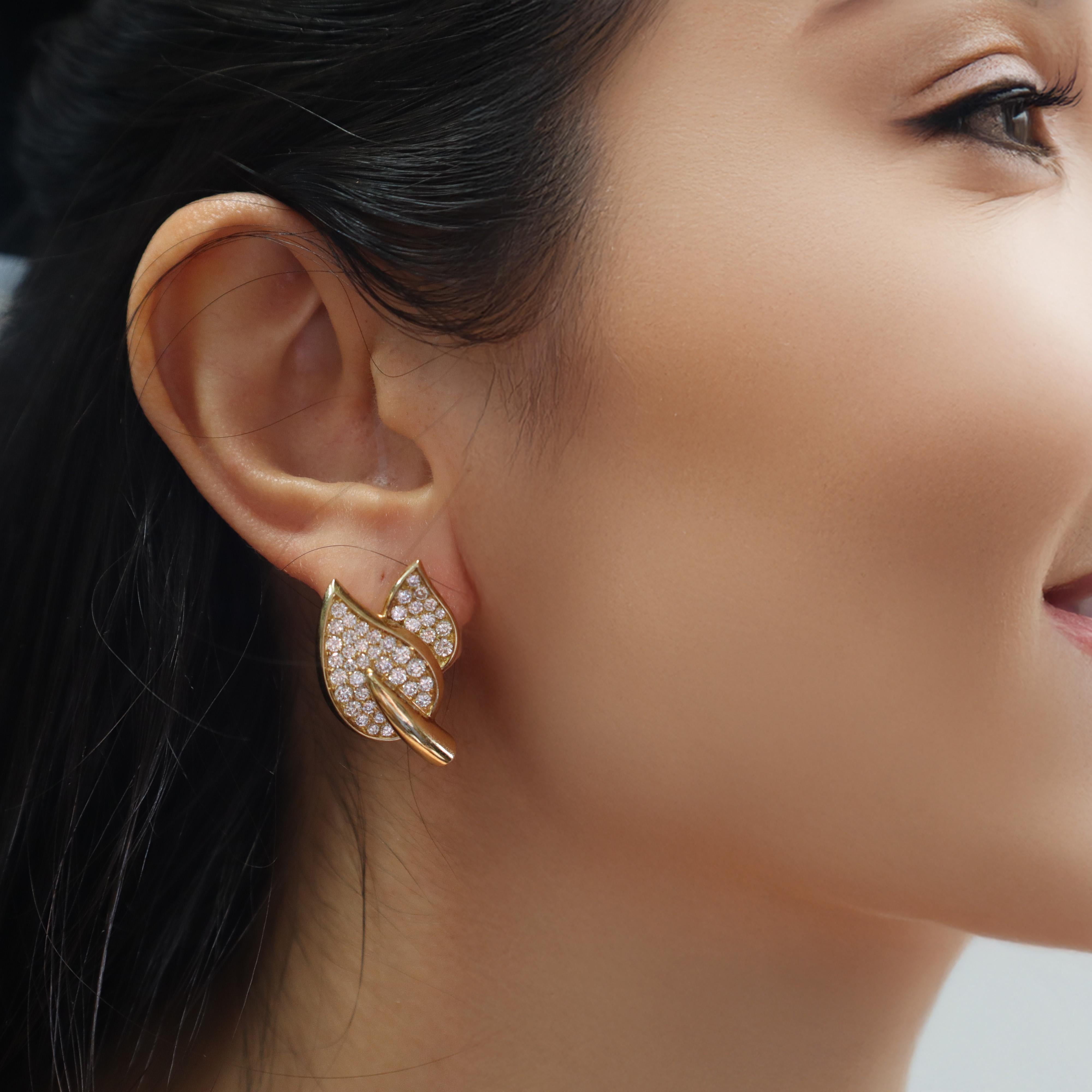 Circa 1970, cette paire exquise de boucles d'oreilles feuilles du milieu du siècle est fabriquée en or jaune 18kt, capturant l'élégance gracieuse d'un design inspiré par la nature. Chaque boucle d'oreille est rehaussée d'un pavé de 82 diamants