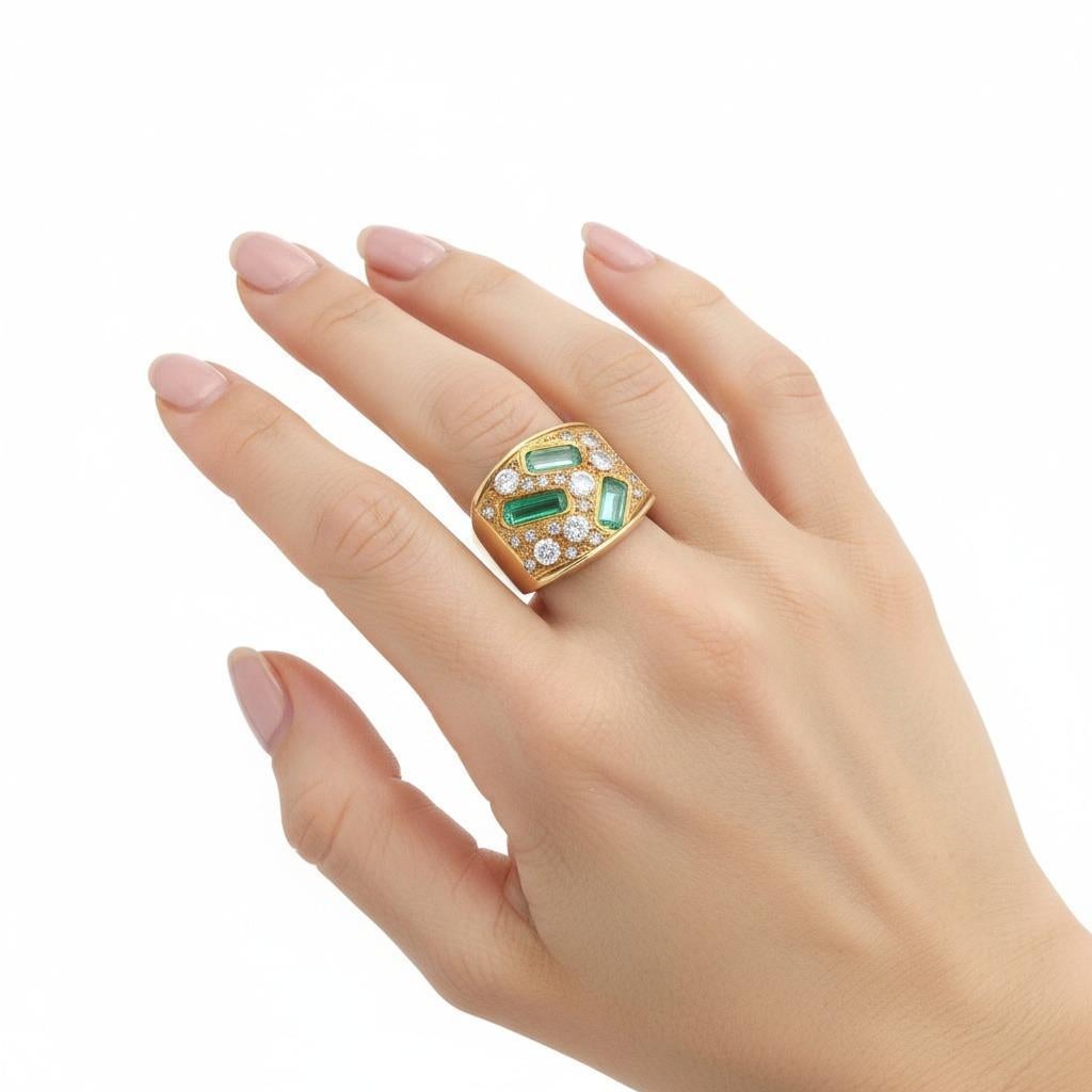 Circa anni '70, questo sorprendente anello di metà secolo è sapientemente realizzato in oro giallo 18 carati e incastonato con tre smeraldi taglio smeraldo per un totale di circa 1,60 carati, che mostrano la vibrante tonalità verde caratteristica