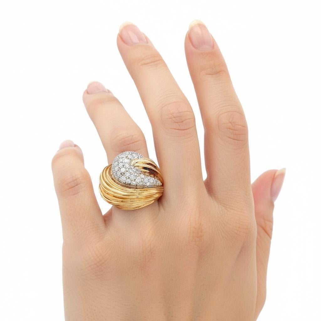 Questo eccezionale anello della metà degli anni '70 esemplifica l'audace raffinatezza dell'epoca, sapientemente realizzato in lucente oro giallo e bianco 18 carati e caratterizzato da una splendida incastonatura a pavé di 60 diamanti a taglio