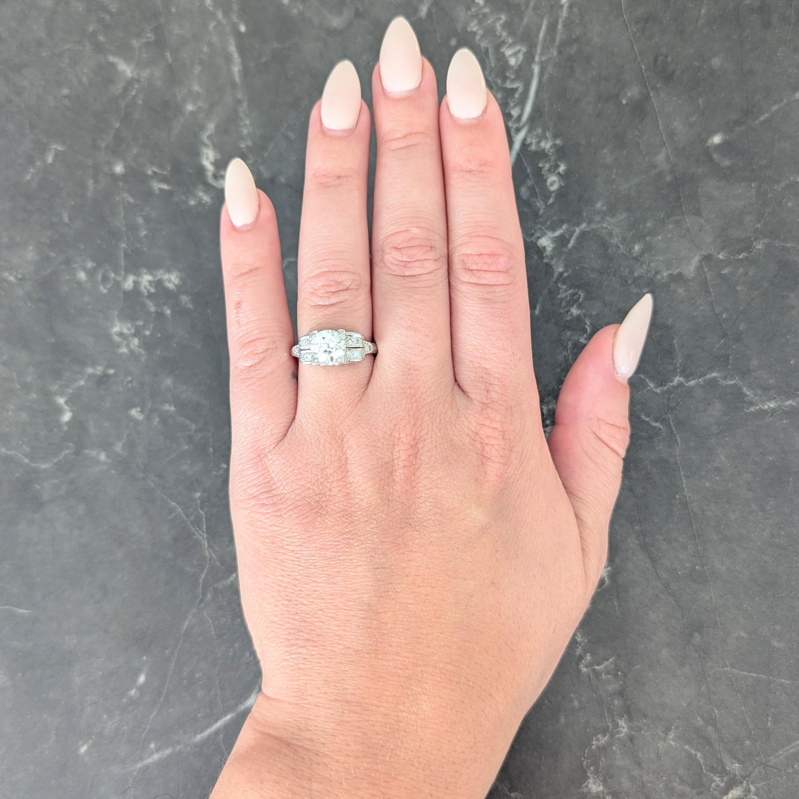 Centering an old European cut diamond weighing 1.59 carats - K color and VS2 clarity
Bead set in a stylized square form head accented by pierced scrolling volute motifs
With a pierced scrolling profile flanked by split shoulders bead set with