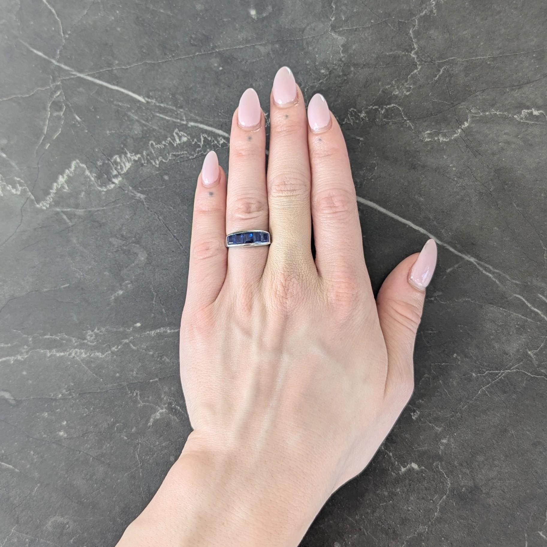 Band ring is channel set east to west with five step cut sapphires
Weighing approximately 1.95 carat total
Transparent medium royal blue in color
Completed by high polish finish
Tested as platinum
Circa: 1950s
Ring size: 5 1/2 and sizable
Measures