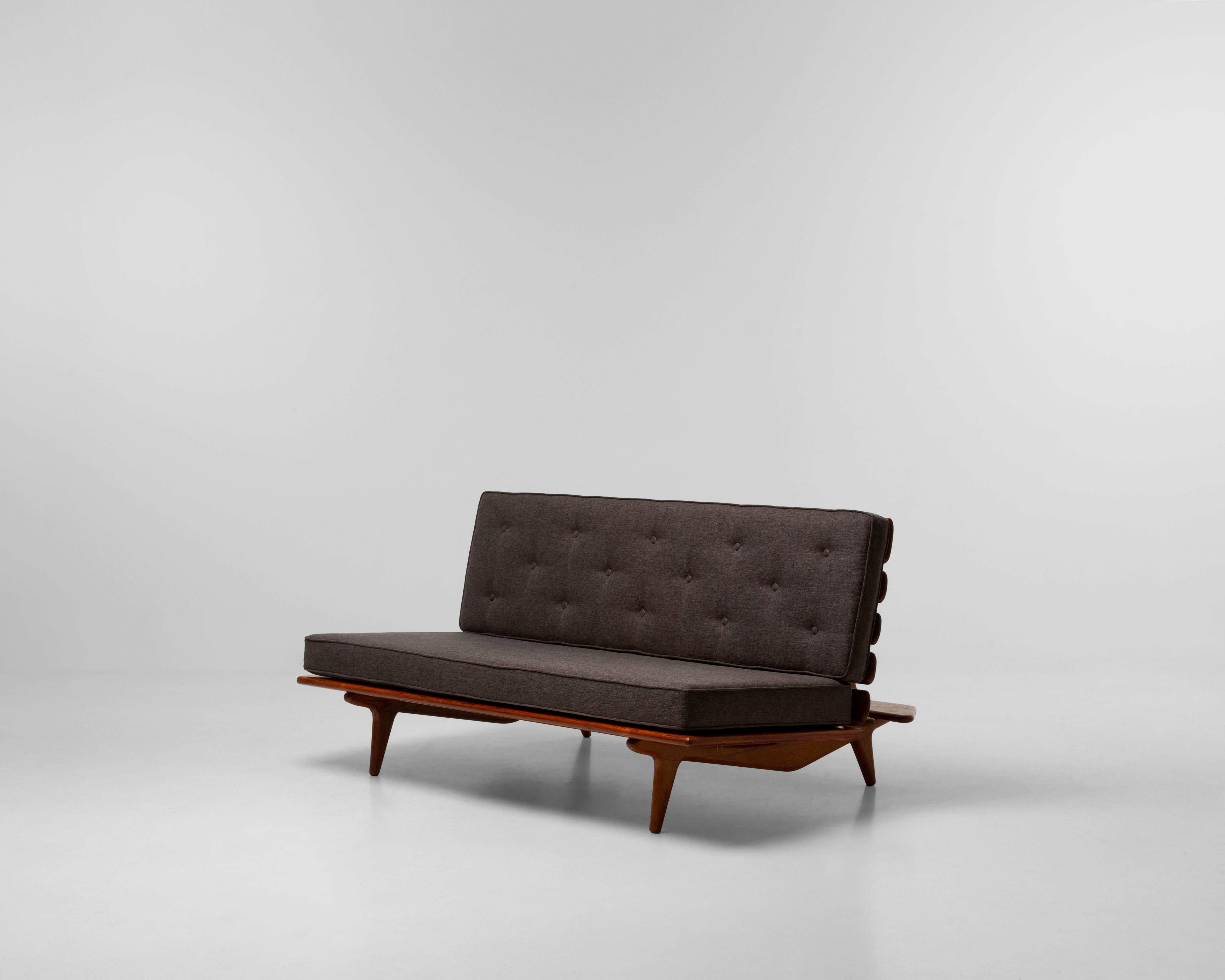 Sergio Rodrigues diseñó el sofá Hauner en 1950. La pieza es característica de la singular estética de Rodrigues y de la sensibilidad de mediados de siglo que defendió. Fabricado con hermosa madera de Pinho de Riga, el sofá es llamativo y cómodo. Las