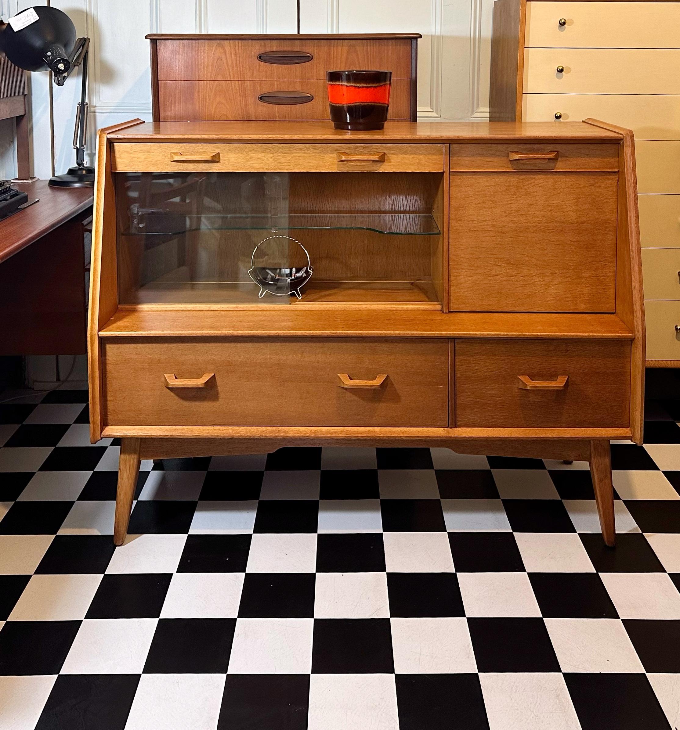 We’re happy to provide our own competitive shipping quotes with trusted couriers. Please message us with your postcode for a more accurate price. Thank you.

Beautiful vintage 1950's oak highboard by E Gomme G Plan. Features one compartment in the
