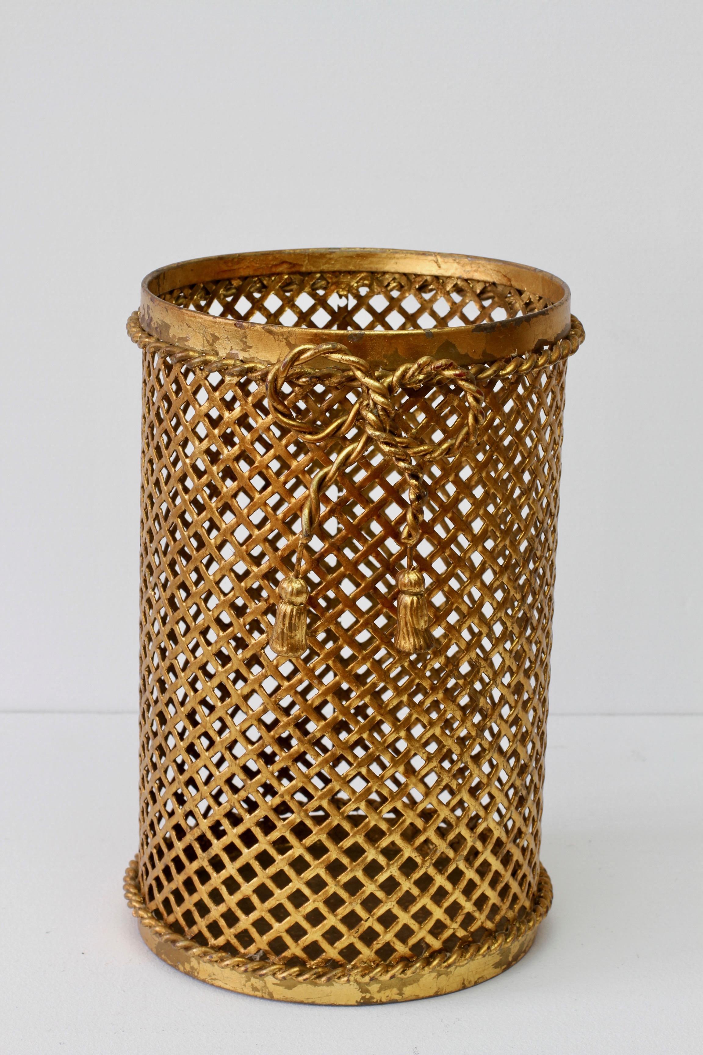 Stunning midcentury vintage gold / gilt / gilded Hollywood Regency style trash can / bin / waste paper basket made in Italy, circa 1950. The perforated lattice patterned metalwork with bent rope and tassel details finishes the piece perfectly. Quite