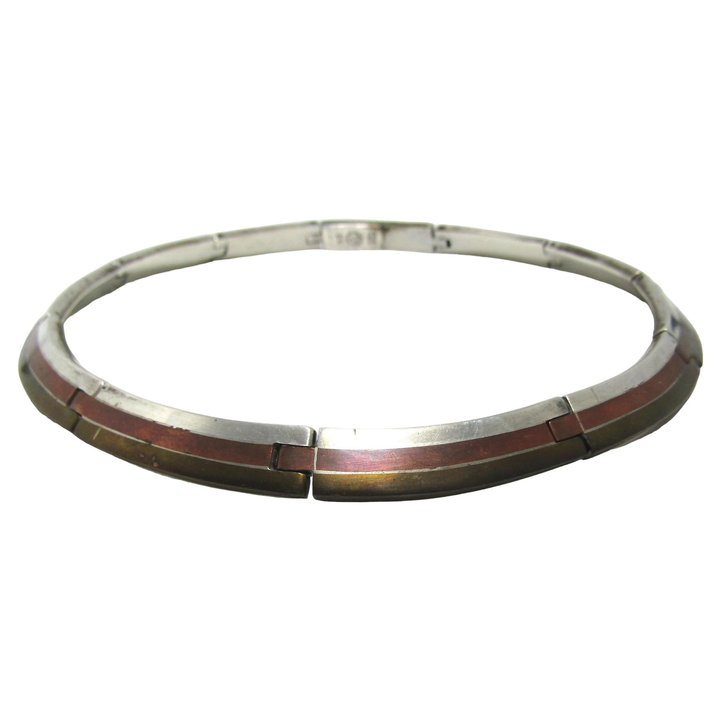 This unique mid-century modern choker necklace was made by Los Castillo of Taxco, Mexico. It boasts sterling silver with an inlay of brass and copper. The weight is a heavy 102g and the length is 16