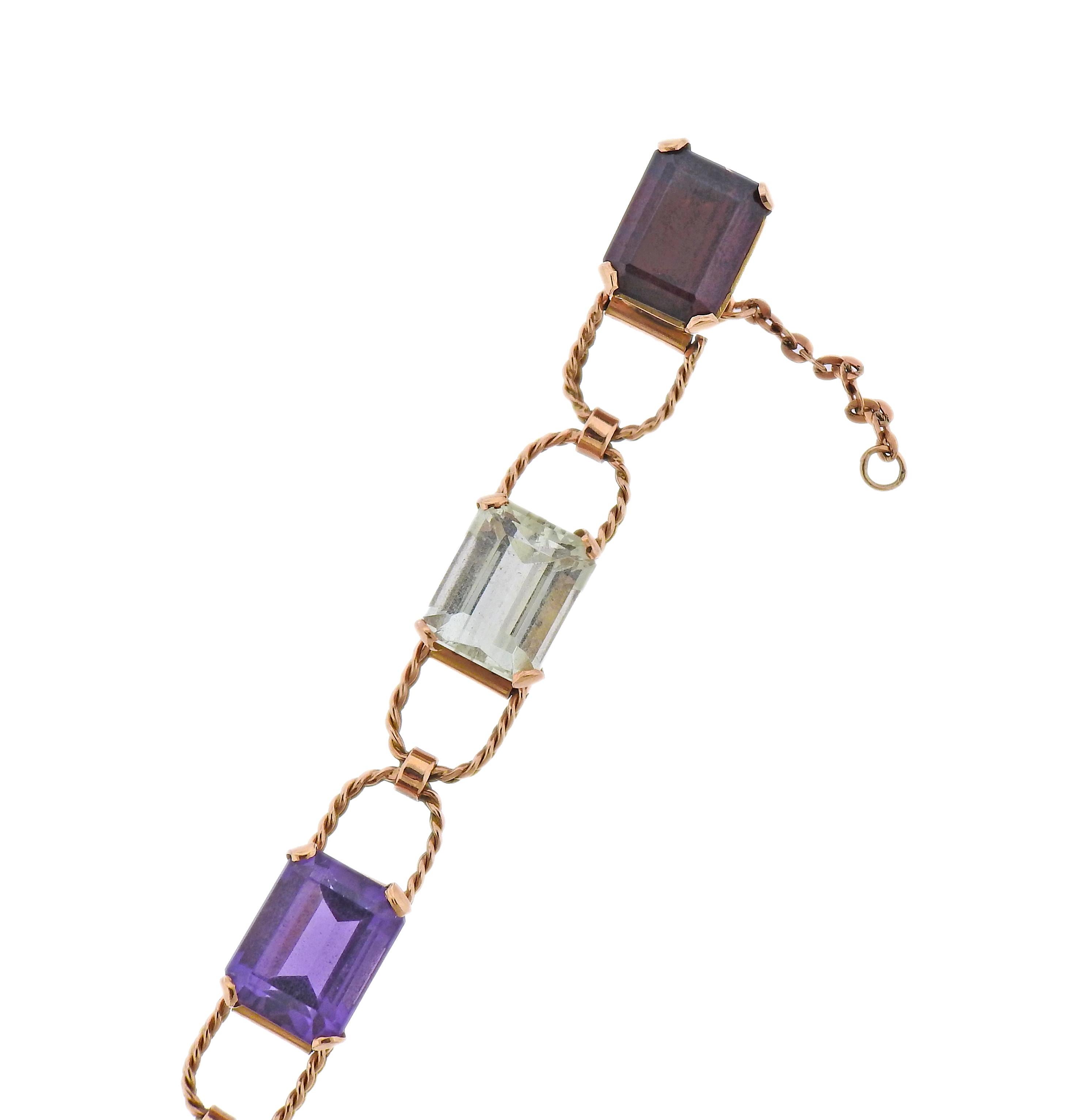 Mid century, circa 1950s, 14k gold bracelet with multi color semi precious gemstones - including amethyst, topaz, citrine, peridot and garnet. Bracelet is 6 7/8