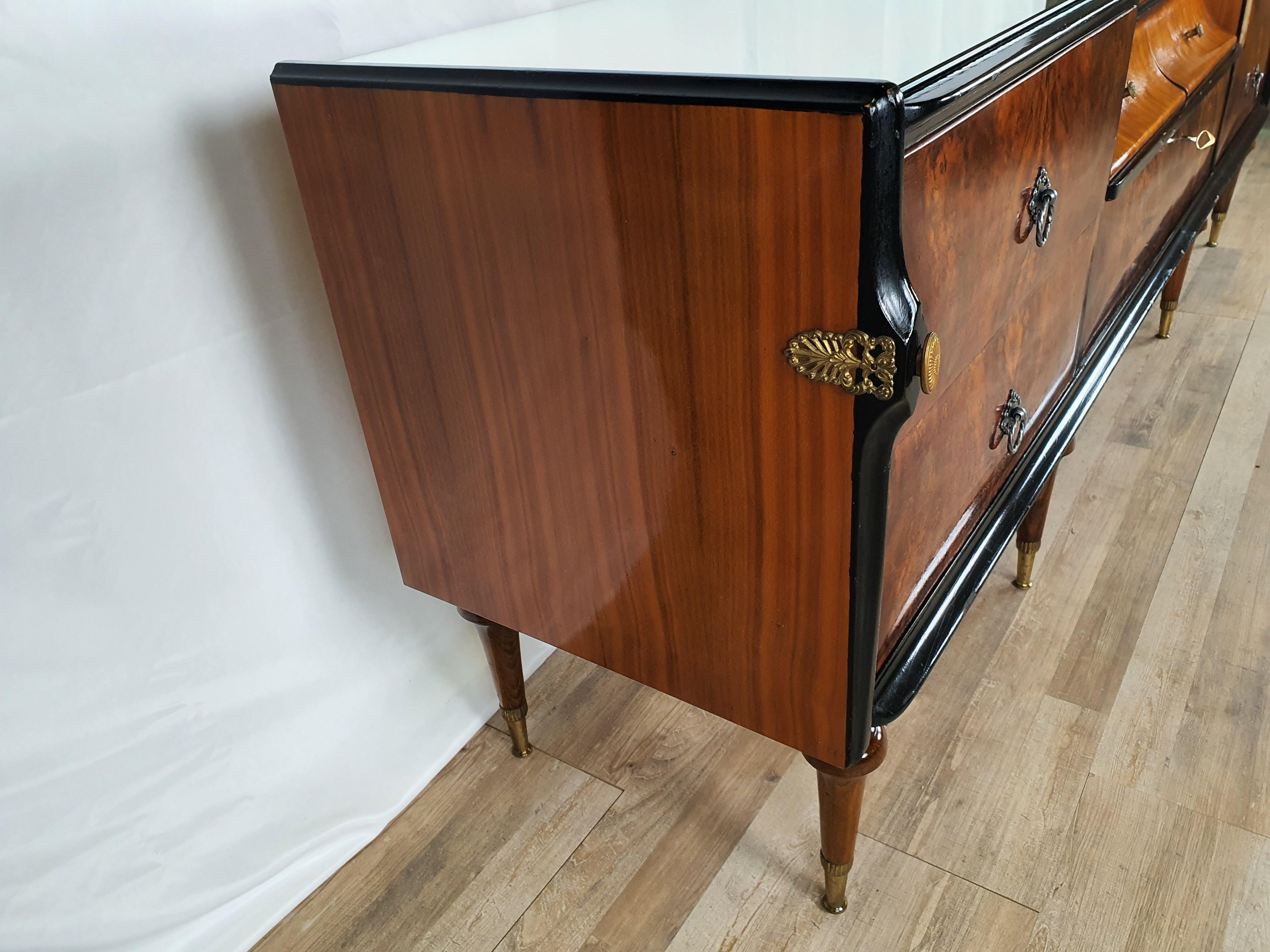 Particular Mid Century sideboard from the early 50s of Italian / Venetian production in chipboard plywood and different essences of wood.

It comes with seven drawers, two side pairs in mahogany briar with ebonized profiles and a smaller central