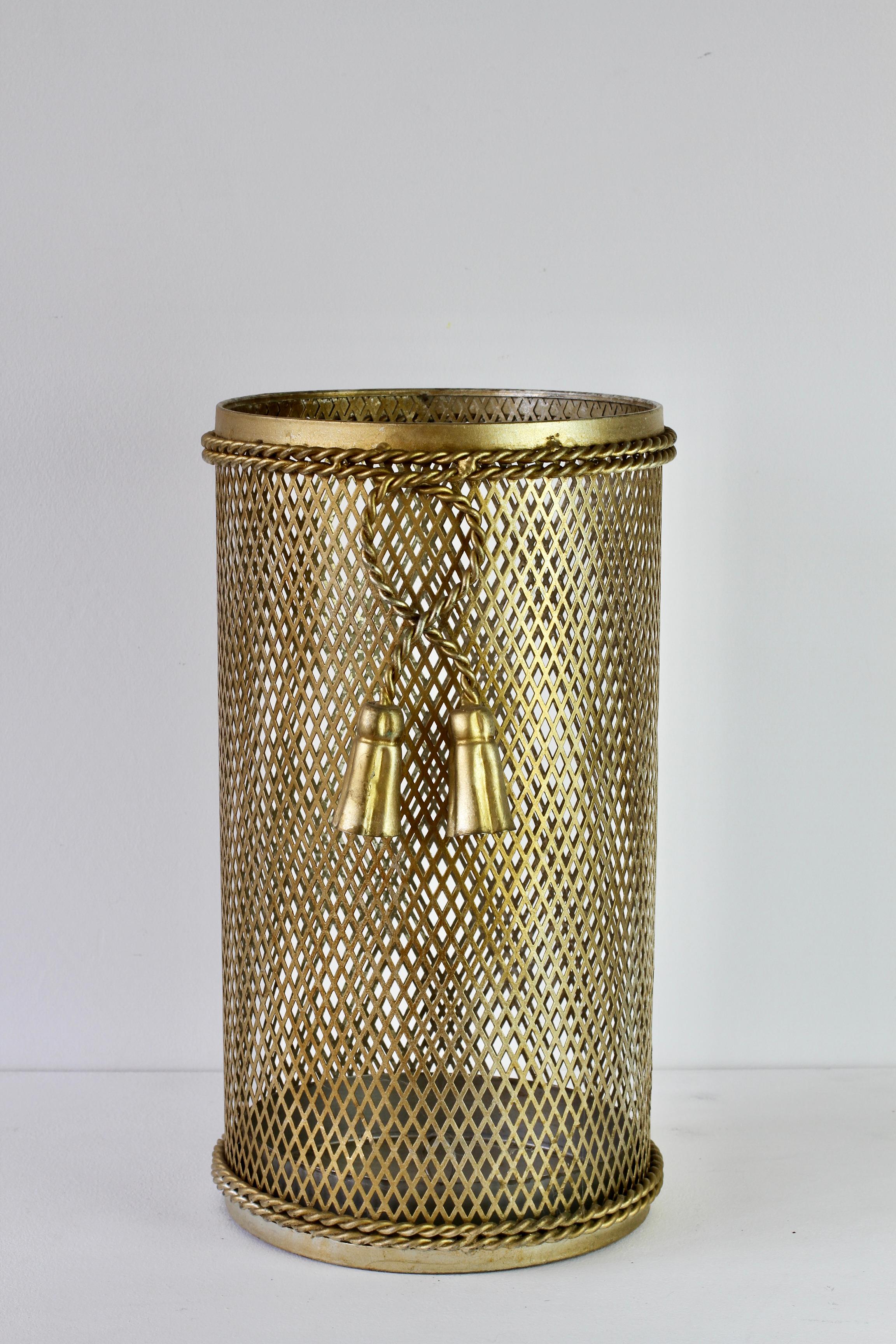 Stunning and vintage Hollywood Regency style trash can / bin / umbrella stand made in Italy, circa 1950. The perforated lattice patterned metal work with bent rope and tassel details finishes the piece perfectly. Quite rare to find this wider size