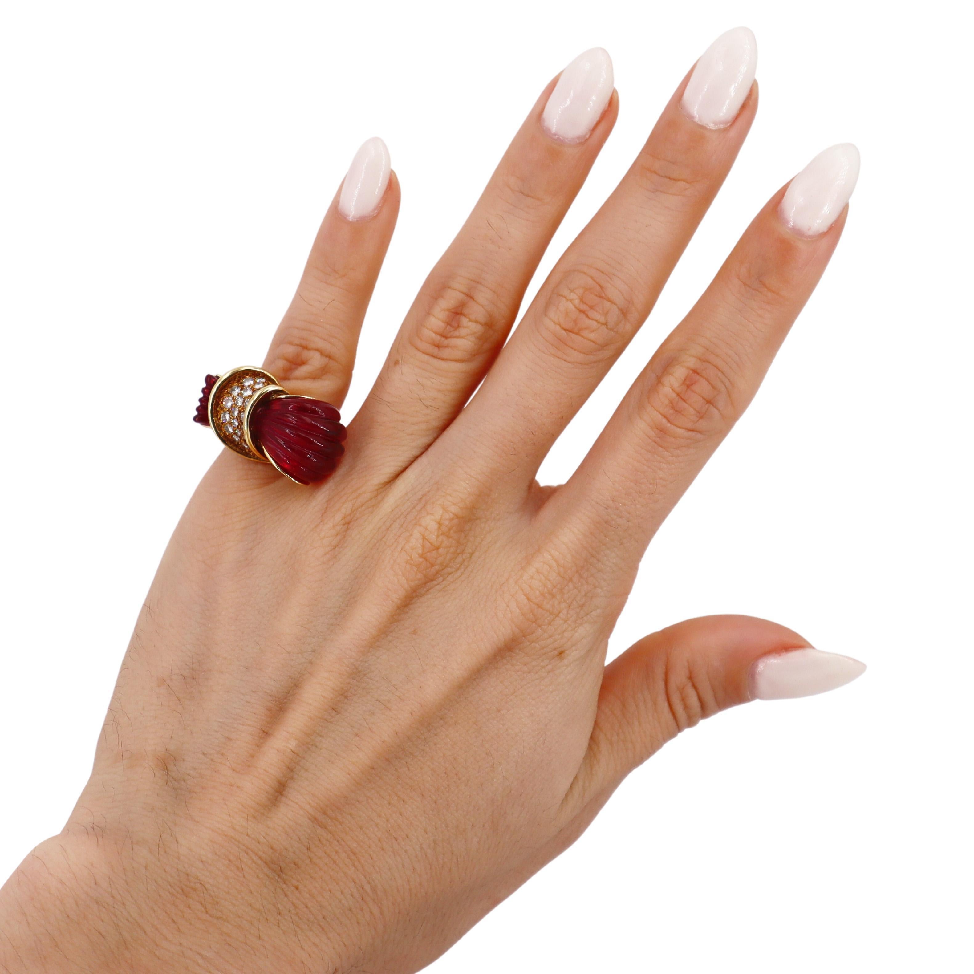 Ti presentiamo uno splendido anello di metà secolo che emana un fascino vintage, sapientemente realizzato in oro giallo 18 carati. Questo squisito pezzo presenta due pietre di rubellite splendidamente intagliate, note anche come tormaline rosa, che
