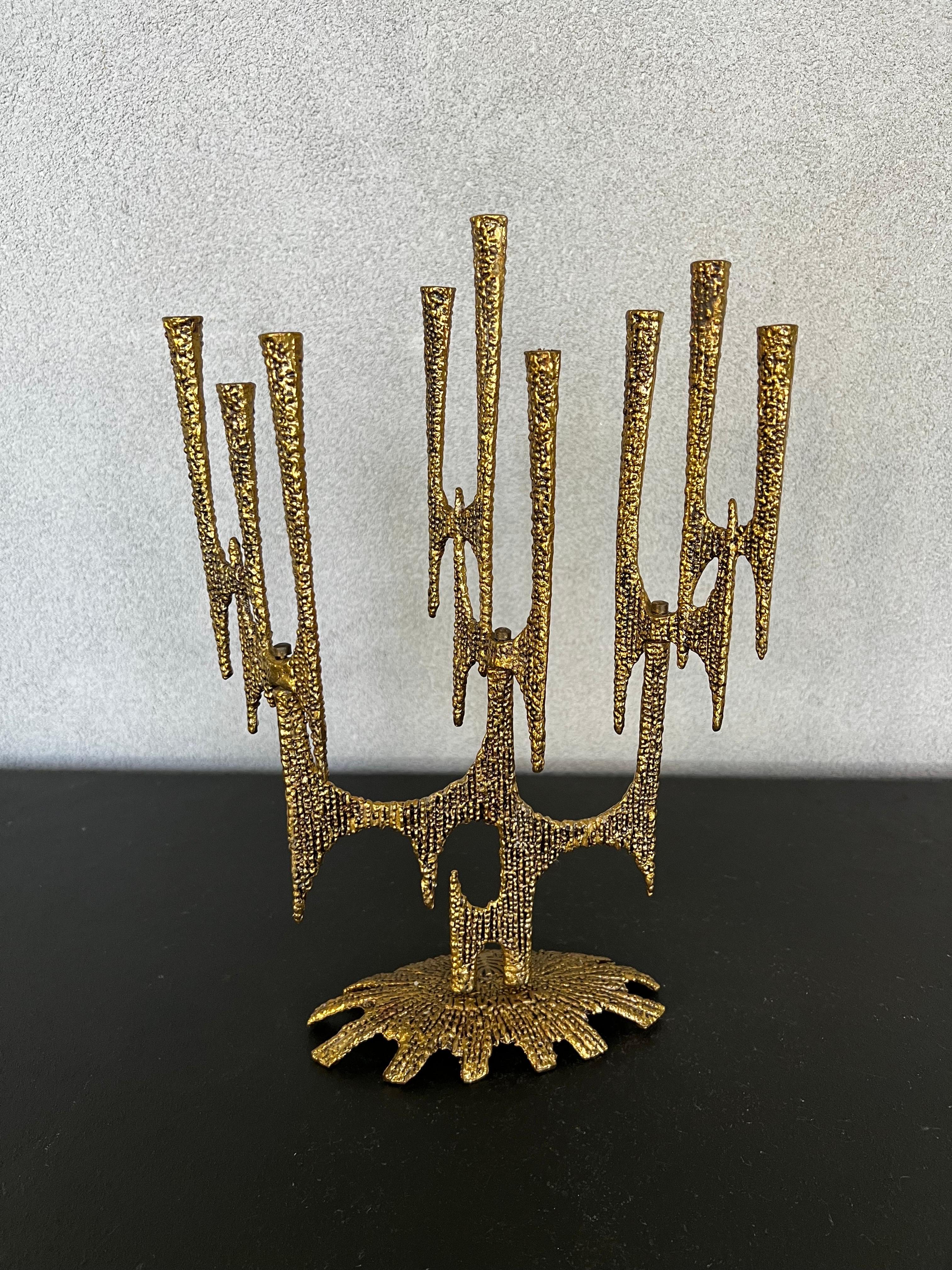 Stunning 1960’s Brutalist menorah handcrafted in brass in Israel. Features a beaded texture along the surface has a drawing of a Menorah and the word “Jerusalem” at the base and nine candleholders which rotate along the articulating stems, designed
