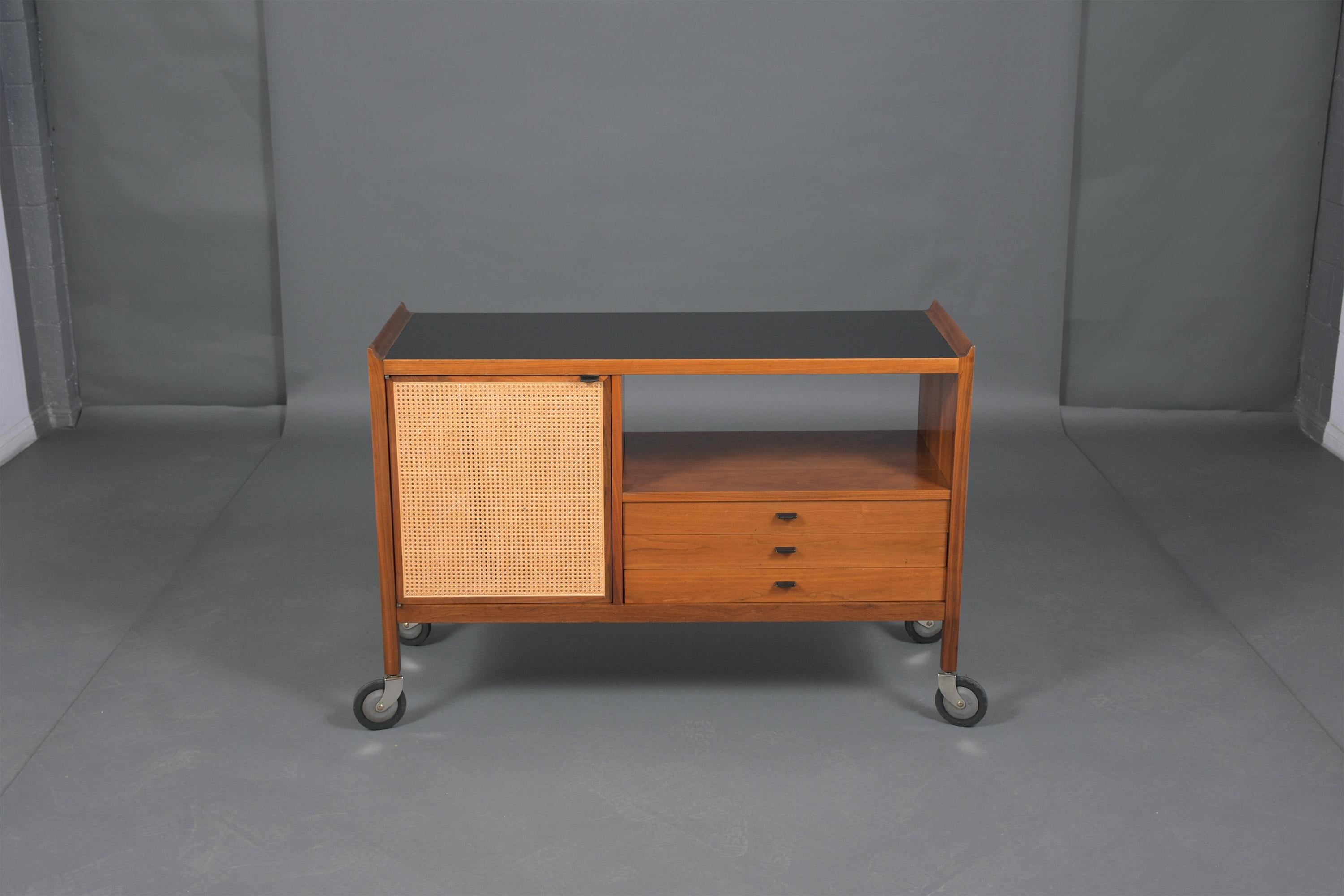 An extraordinary mid-century Danish Drybar hand-crafted out of teak wood in great condition this piece has been professionally restored by our team of in-house and features walnut color with lacquered finish a black color Formica top an underneath