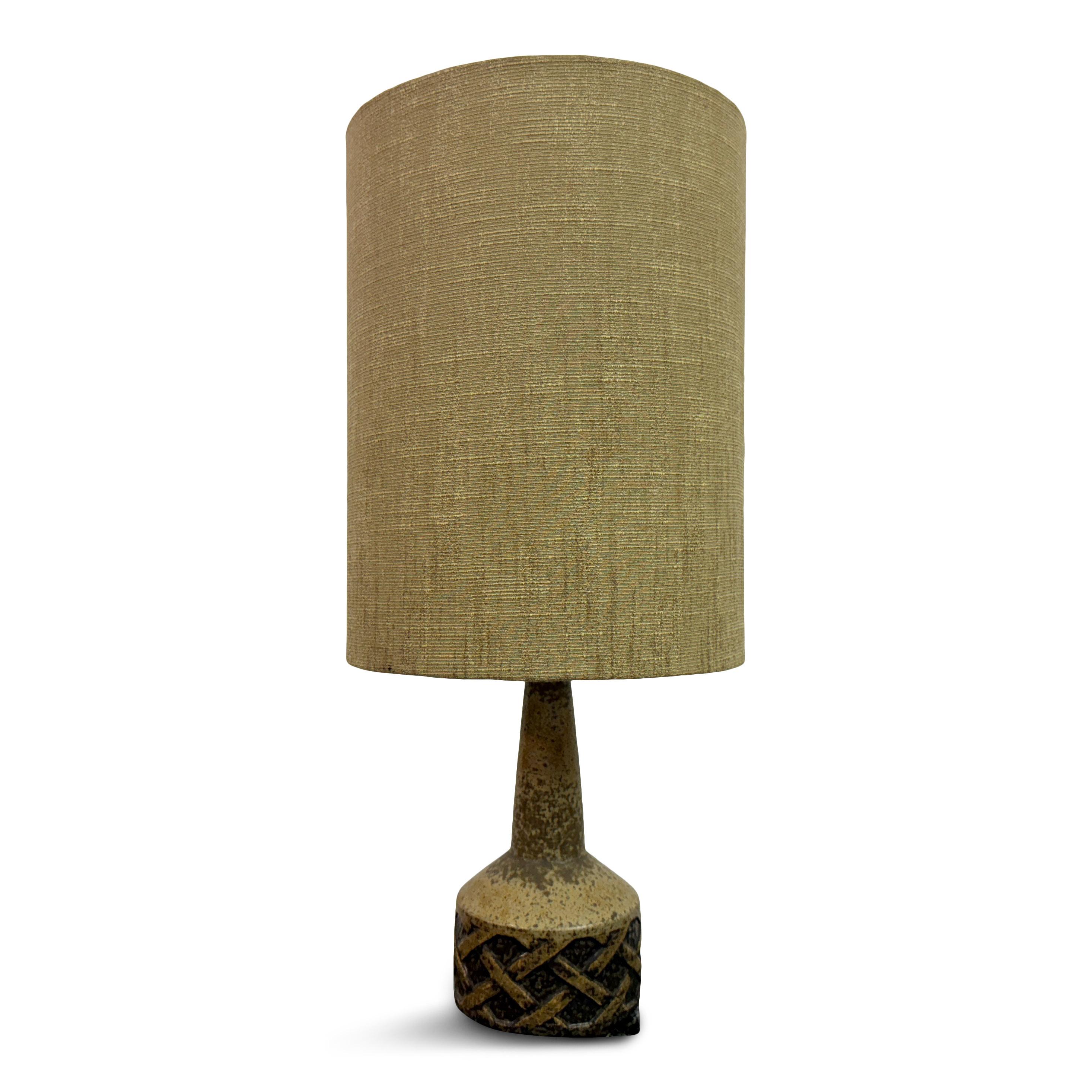 1960s Ceramic Table Lamp by Søholm Stentoj. 

This table lamp, from Danish maker Søholm, has a distinct mid-century design. The base is crafted from ceramic with a textured, earthy finish. The lower part of the base features an intricate, embossed