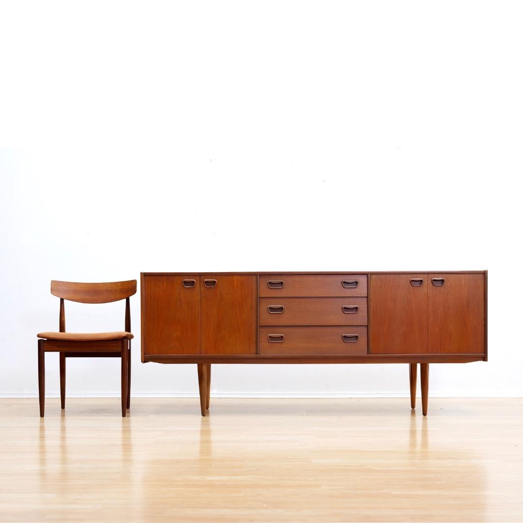 Questa credenza vintage è stata prodotta in Danimarca negli anni Sessanta. Un mobile classico in teak dal design minimalista e dalla costruzione solida, tipico dell'epoca. Grazie all'ampio spazio di archiviazione, costituito da un armadietto su