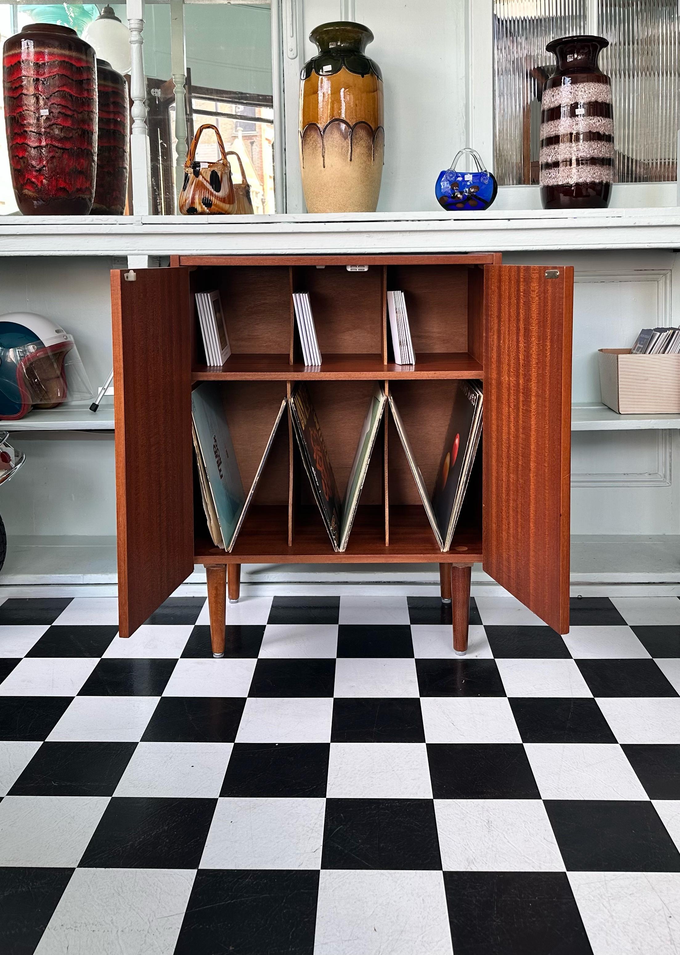 Mid-Century 1960’s Danish teak vinyl / Record cabinet. Features six storage compartments inside and beautifully carved handles. Offers plenty of storage. Rests on stylish tapered legs.
Very good vintage condition with some minor signs of