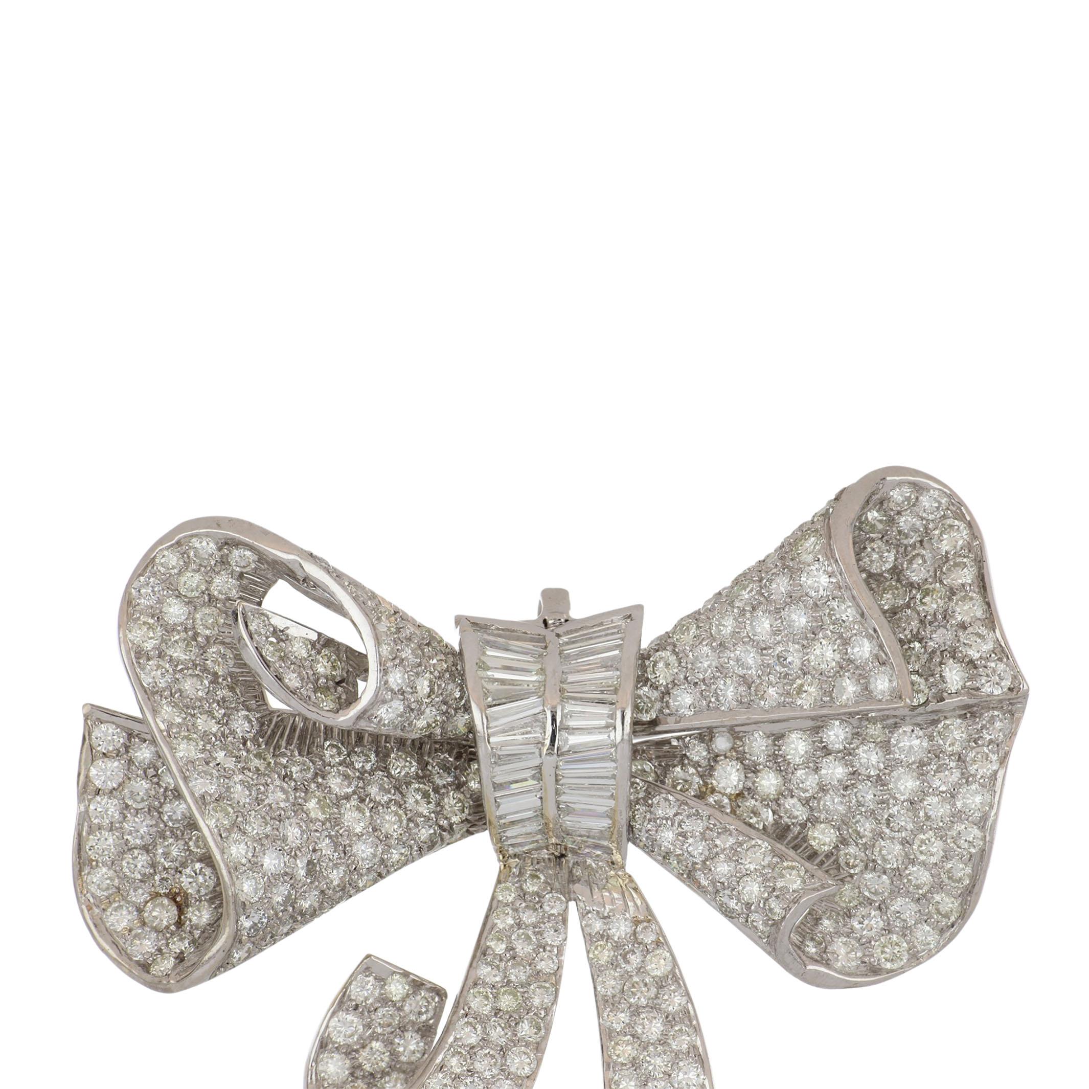 Mid-century 18K white gold bow brooch with 323 round and baguette diamonds that total 13.65 carats; G-I color and VS clarity.  There is also a bale so it can be worn as a pendant.  Circa 1960.  The brooch measures 2.25 x 2 inches.