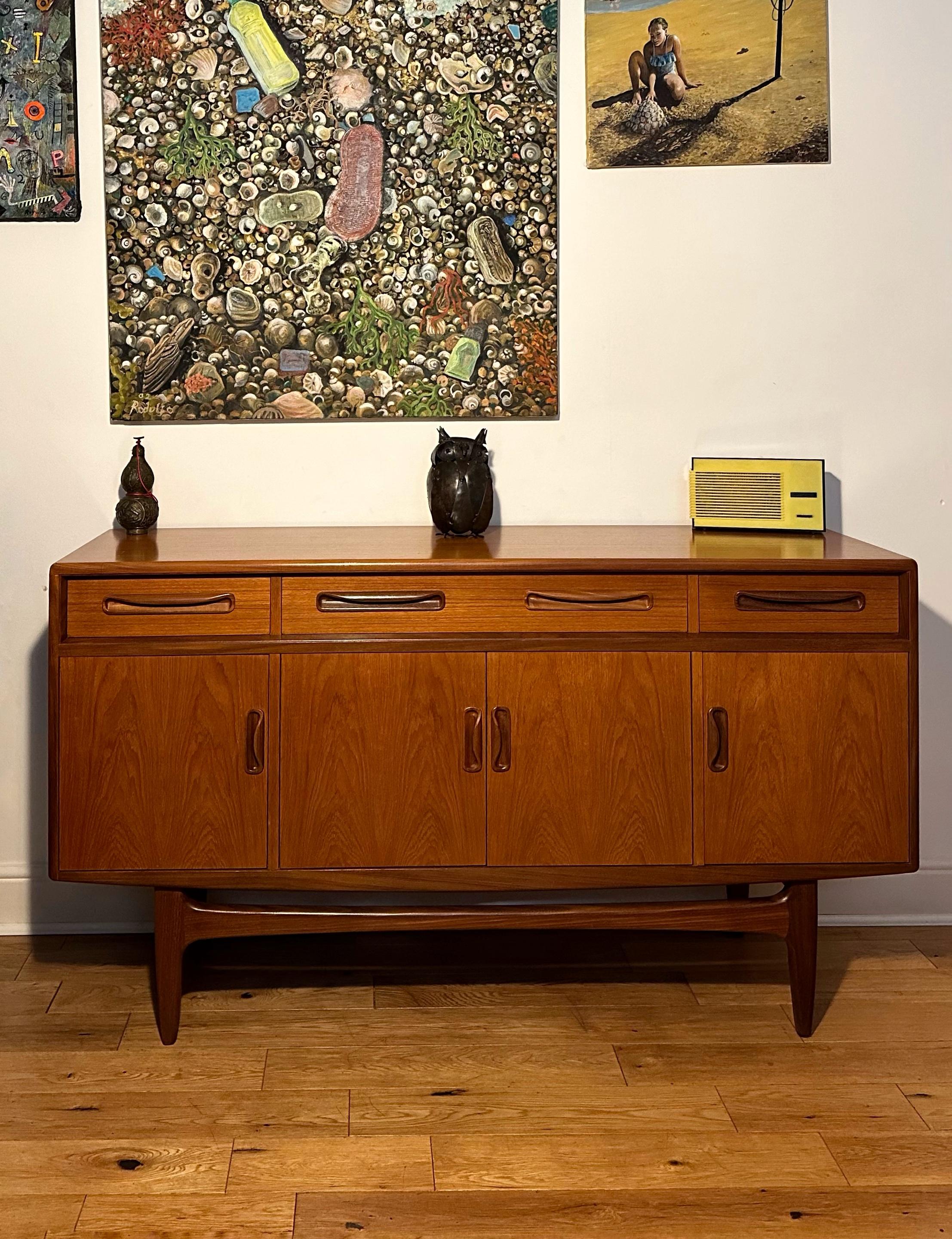  This beautiful sideboard was manufactured by G Plan in the 1960’s. 
Features three spacious cupboards with removable/adjustable shelves inside and three drawers. 
The sideboard rests on stylish tapered legs. Beautiful golden teak grain throughout -