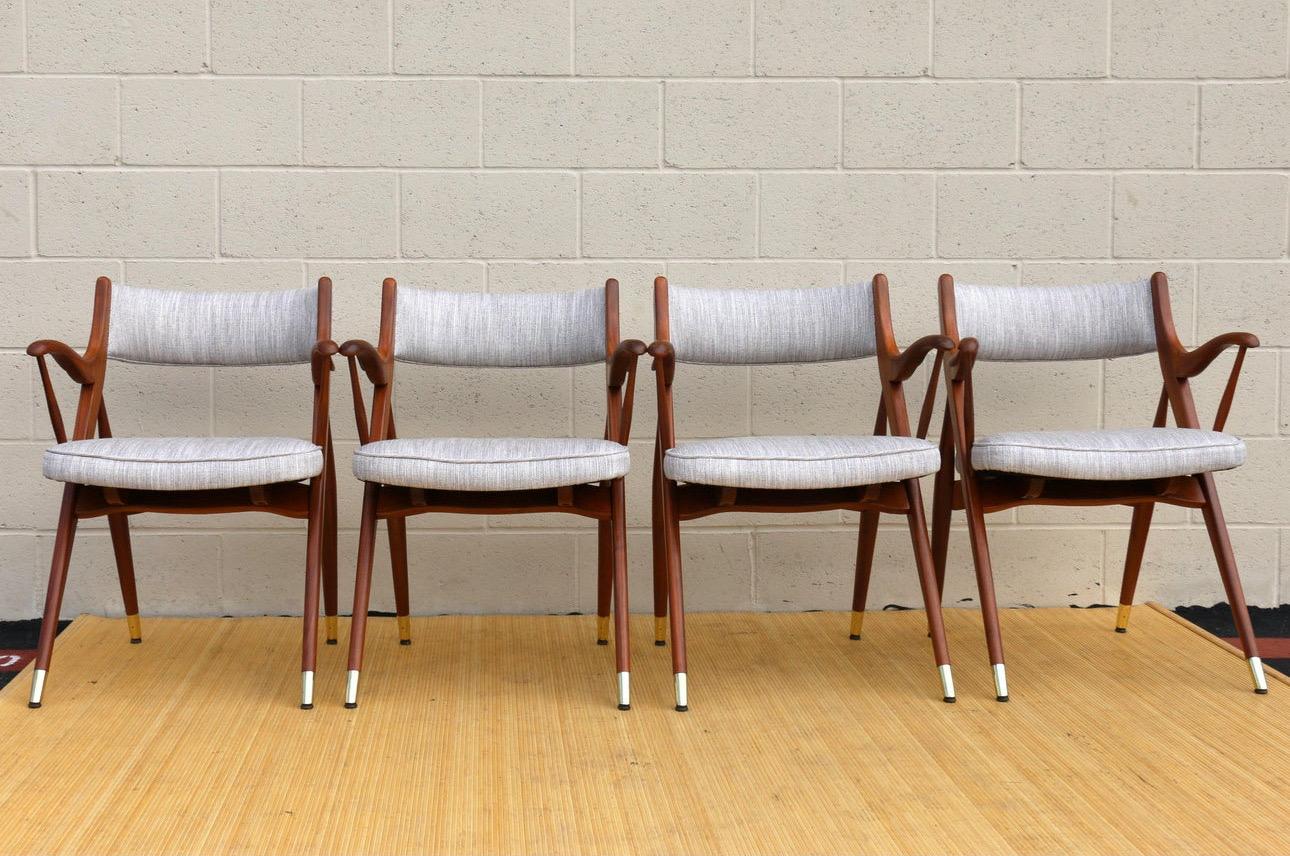 Spectaculaire ensemble de quatre fauteuils de salle à manger Mid Century, originaux des années 1960. Ces chaises ont un look étonnant et un design unique. Ils sont fabriqués en bois de noyer et ont de magnifiques accents de laiton dans les pieds.