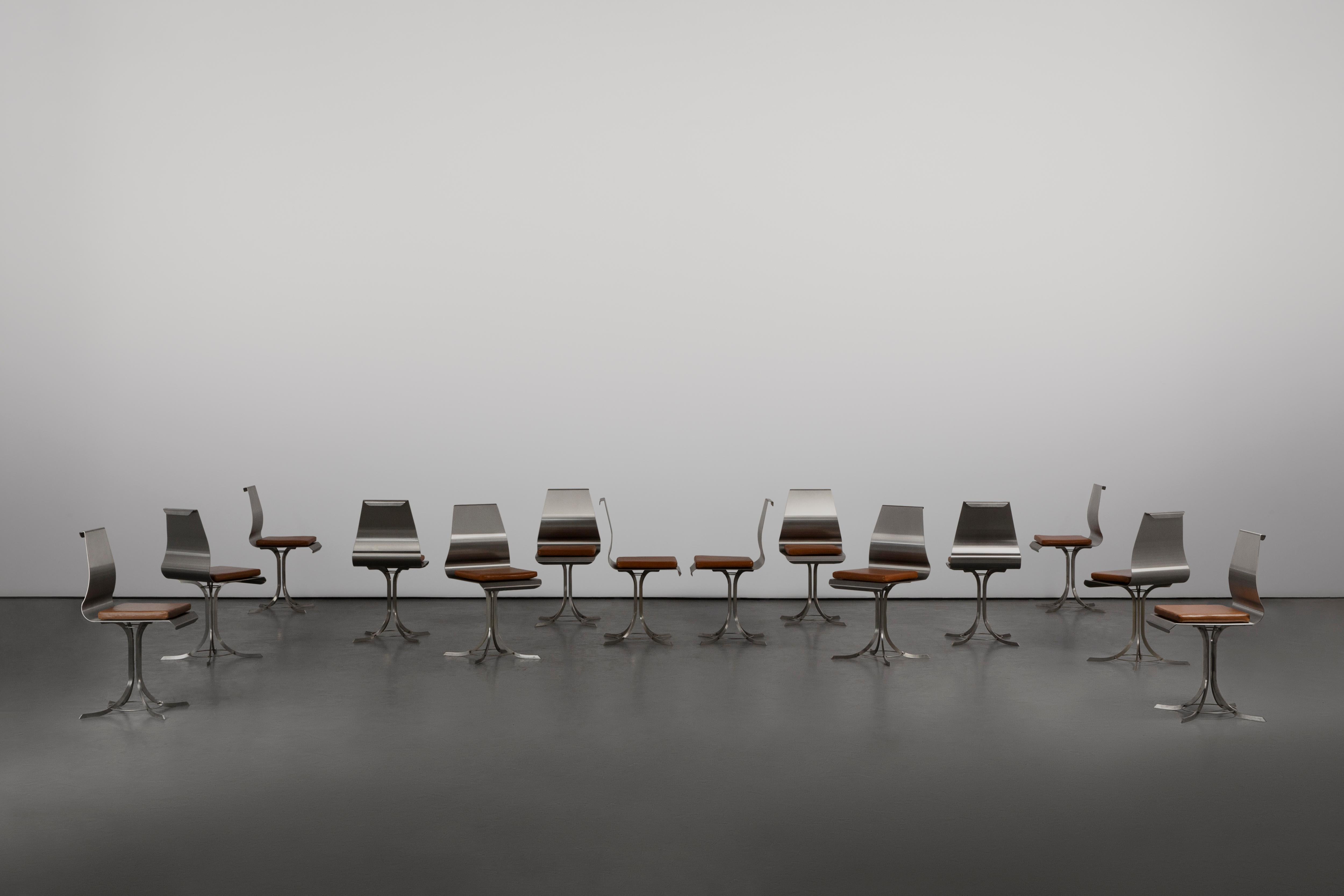 These chairs by Xavier Féall embody a striking blend of minimalism and sculptural presence, where functionality meets pure artistic form. The set of 14 showcases his mastery in working with industrial materials, most notably brushed steel, which