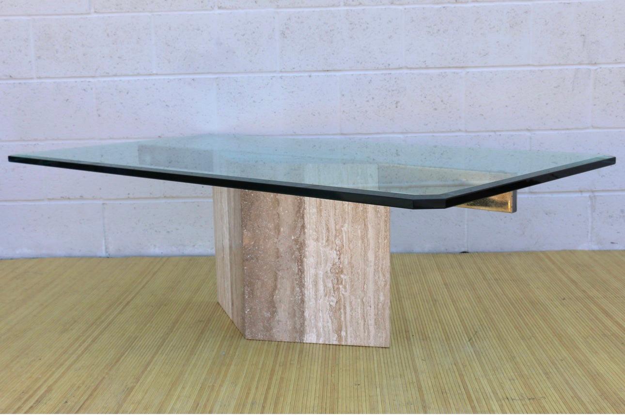 Beautiful Italian coffee table made of a rhombus travertine shape and rectangular glass top. It was made in the 1970’s. It reminds in good original condition. The glass top has no chips, it has some minor scratches, not really notable. The