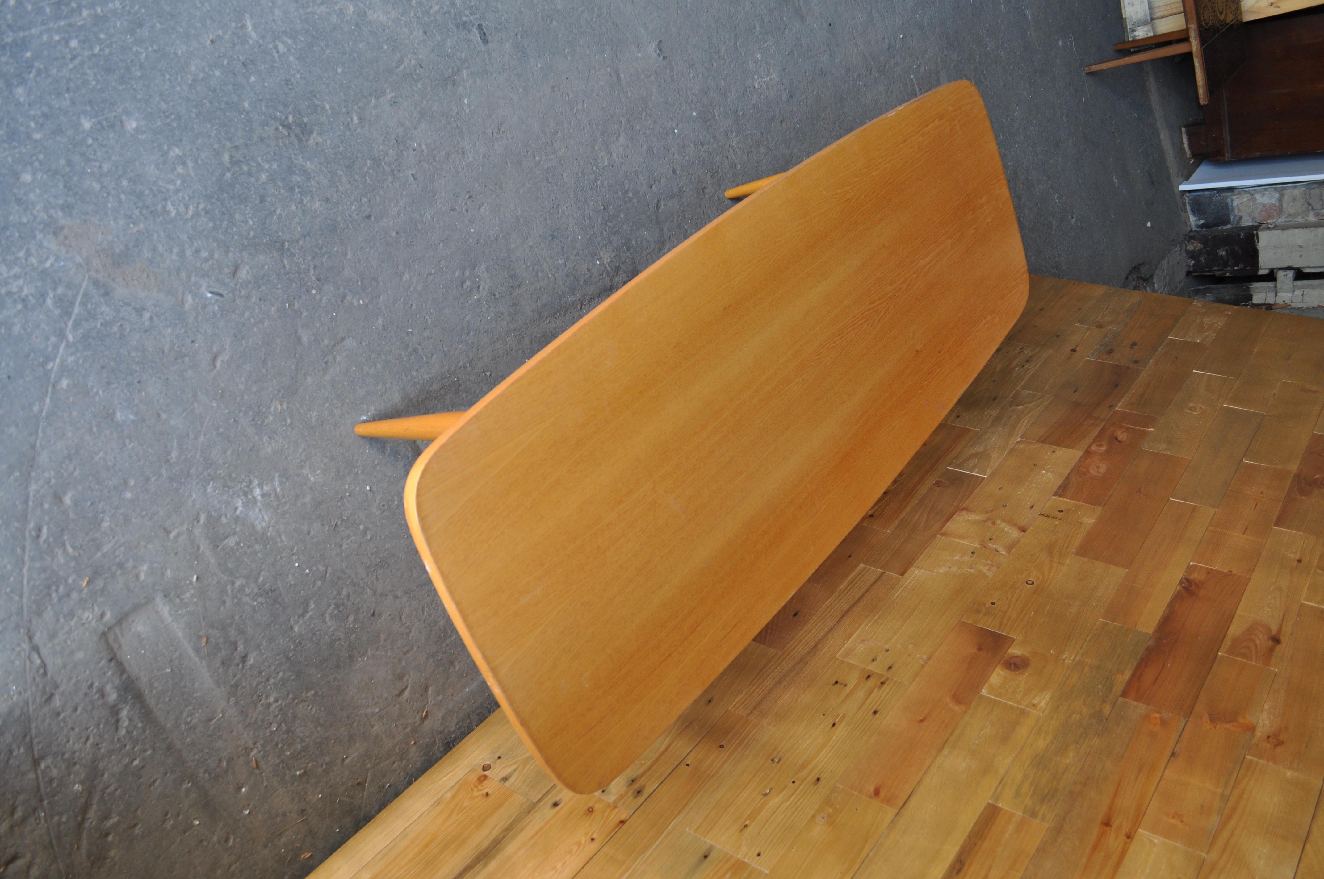 Original midcentury surf board style long coffee table. This light maple coffee table is set on top of solid beech legs with a magazine rack. The coffee table has a very nice gloss varnish finish that suits the light maple wood and really gives the
