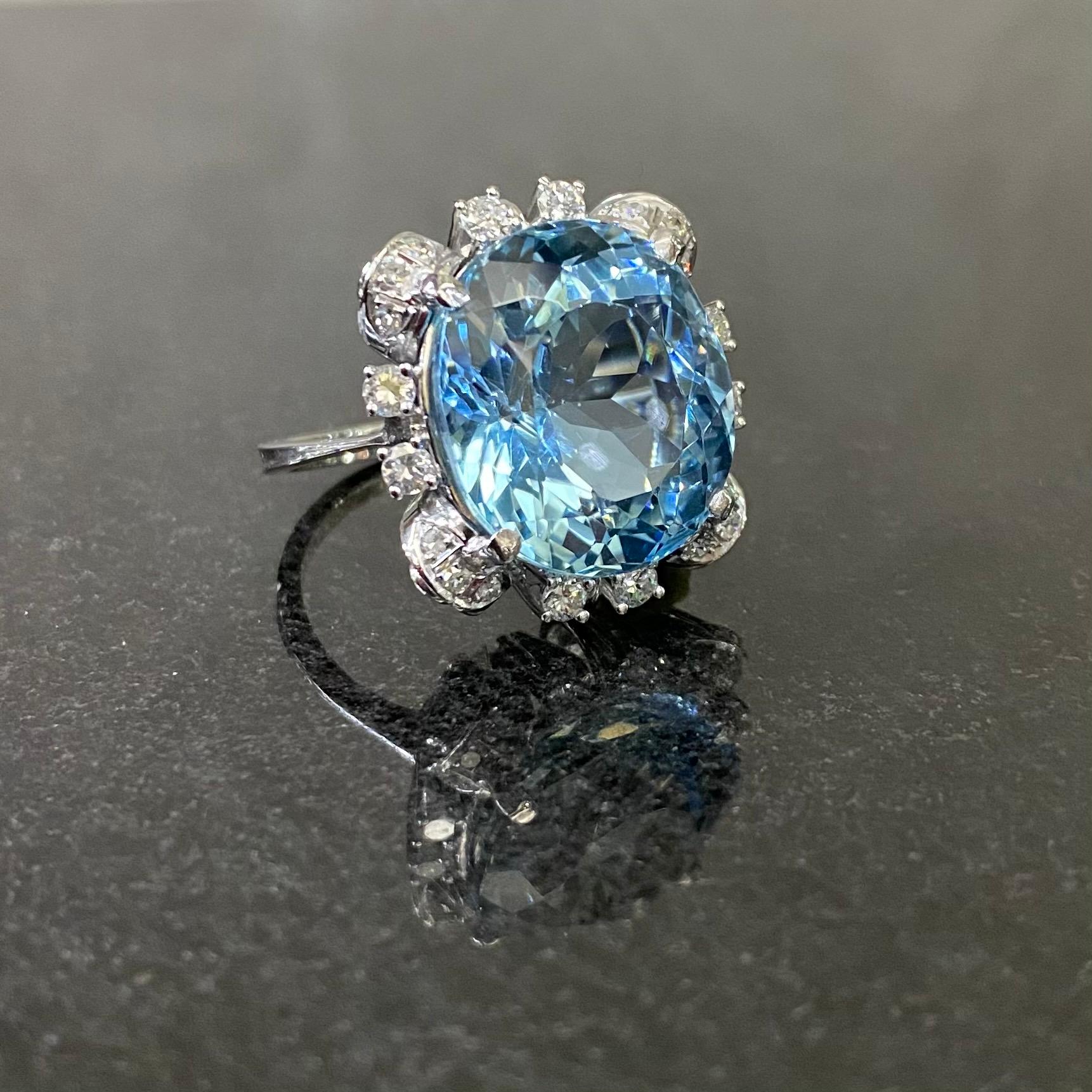 A Mid-Century Aquamarine and Diamond Cocktail Cluster Ring in White Gold, Portugal, c. 1952-1975. Featuring an intense blue oval-cut aquamarine claw-set to the centre, encircled by 20 round brilliant-cut and single-cut diamonds, to an architectural