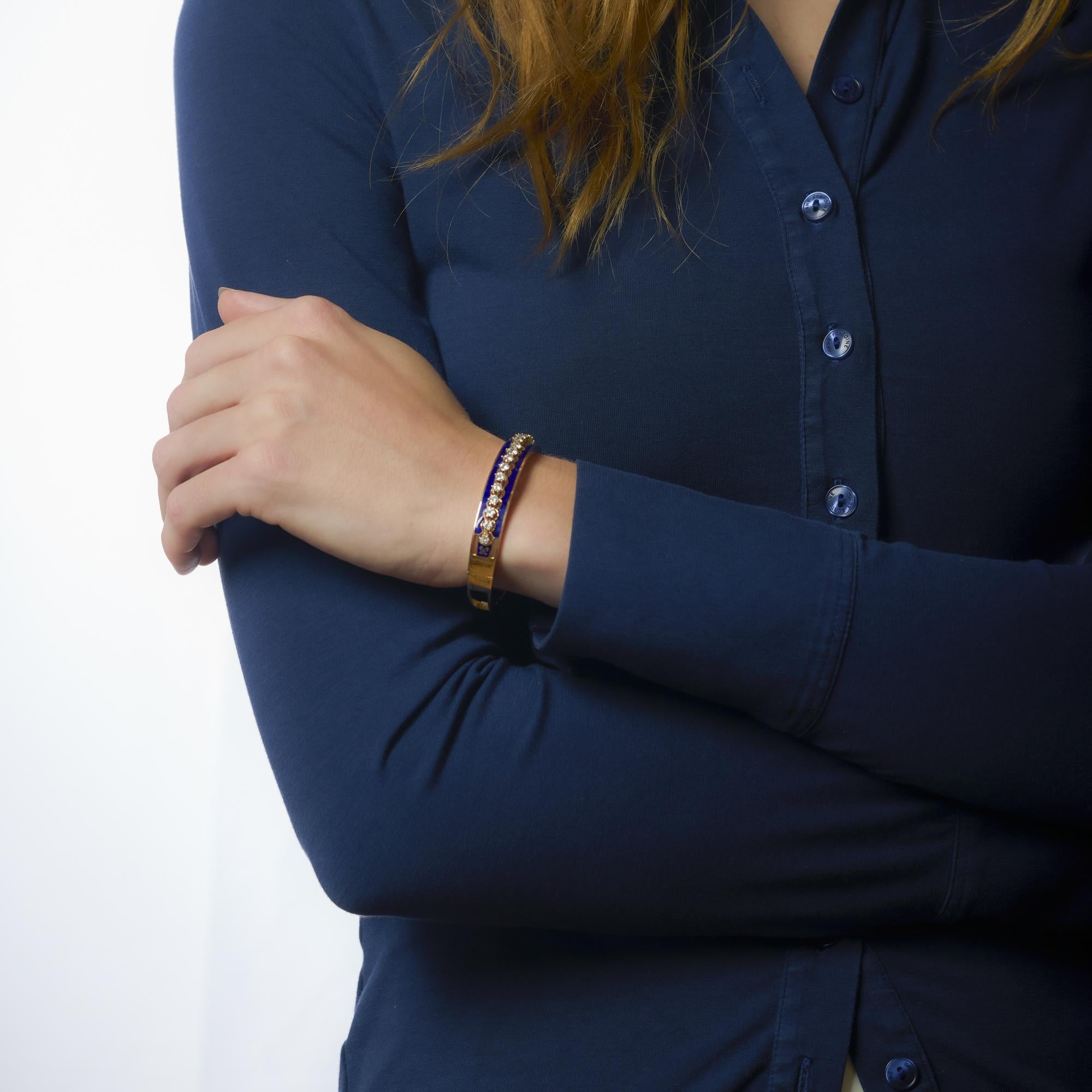 Esta llamativa pulsera Mid Century combina un rico esmalte azul con 17 brillantes diamantes de color F en oro de 14k, irradiando un refinado glamour vintage y un atrevido diseño.