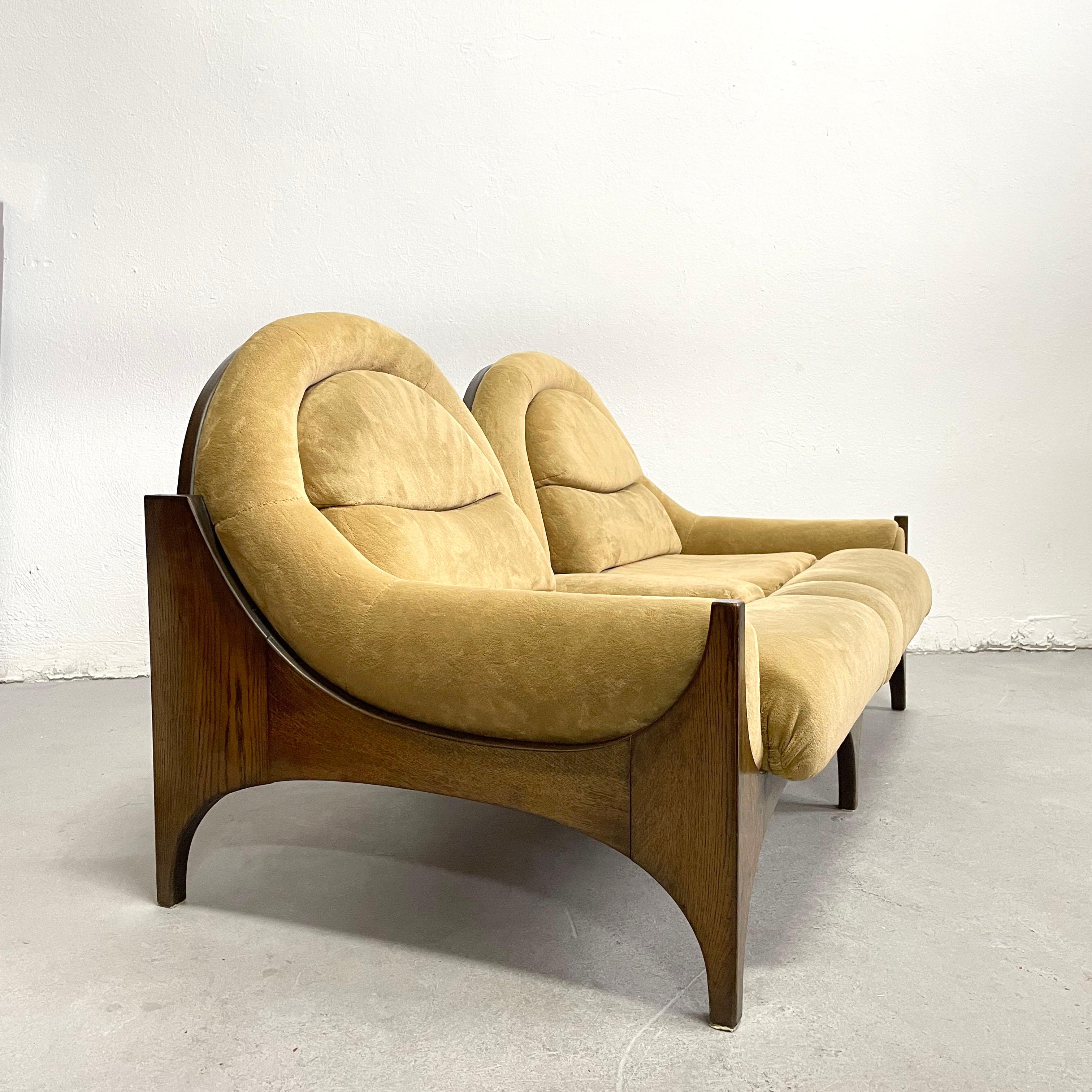 Stunning mid-century 2-seat sofa manufactured in Austria in the 1960s.

The designer and the manufacturer are unknown.

The form of the wooden frame is reminiscent of the works of Austrian born designer Henry P. Glass.

The walnut colour wooden