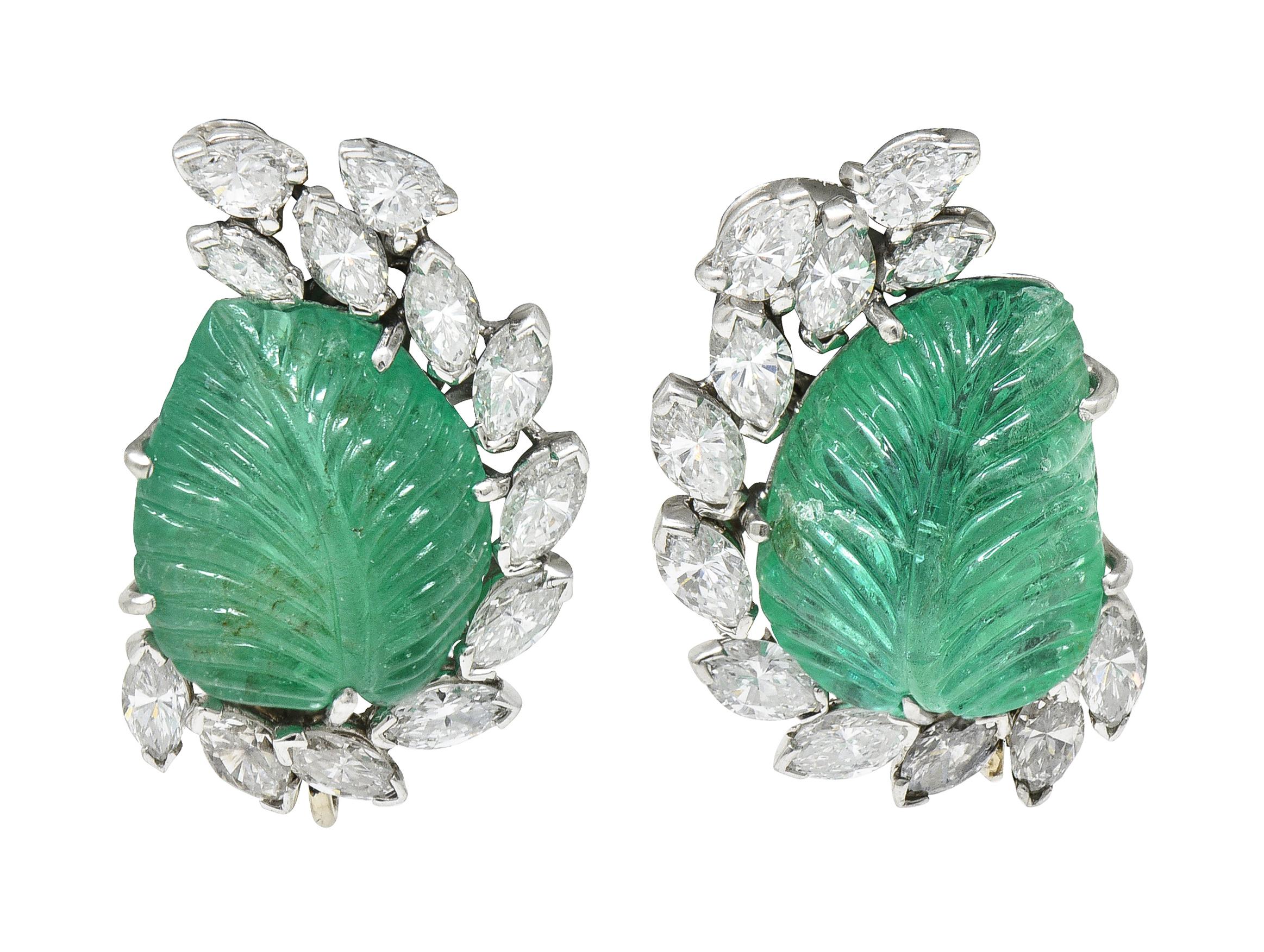 Cluster ear-clips are designed to feature Mughal carved emerald with a half halo of marquise and pear cut diamonds

Emerald is pear shaped and deeply carved to depict a leaf motif while weighing in total approximately 20.00 carats

Very slightly