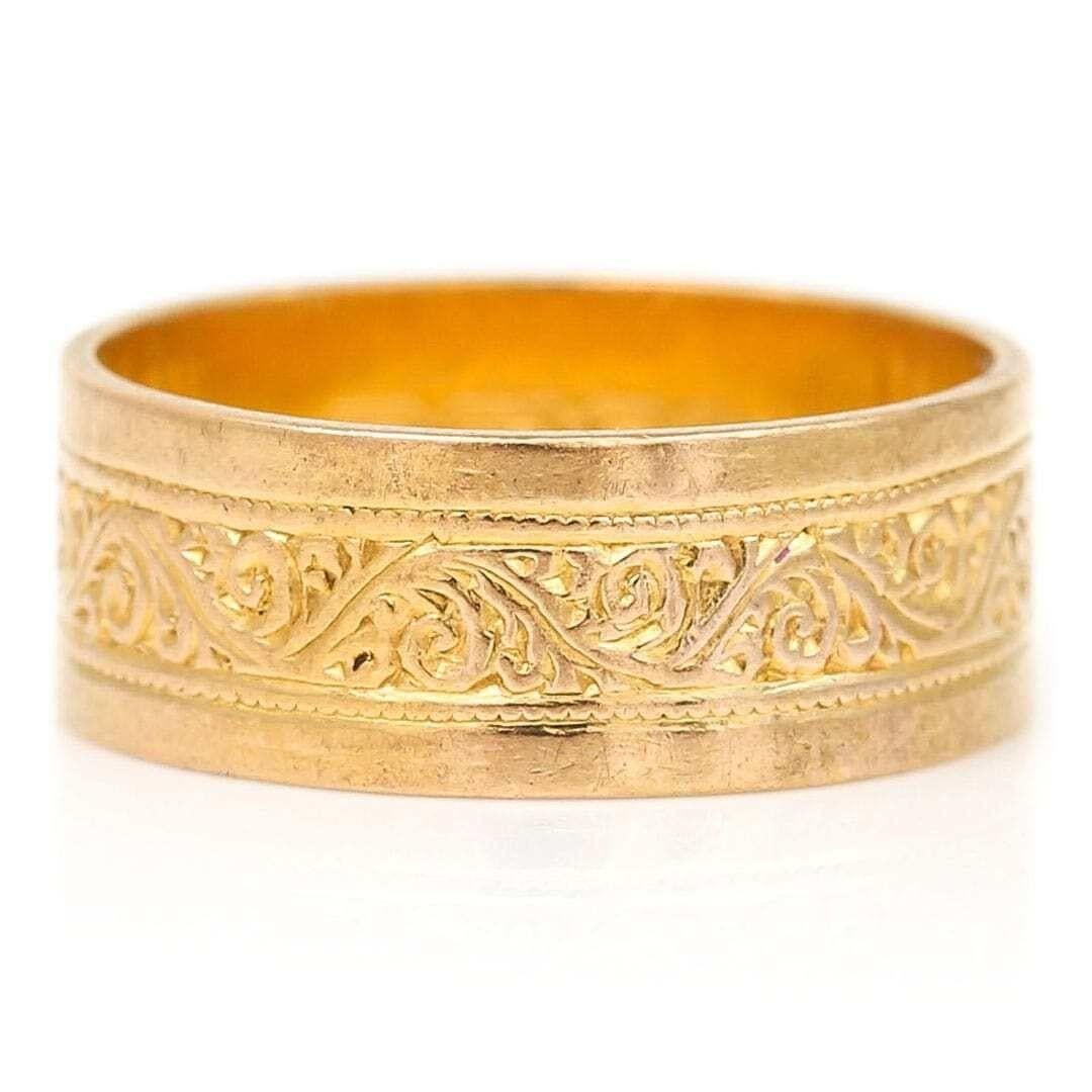 A very pretty mid-century 22ct yellow gold florally, scrolling engraved wedding ring dating from circa 1959. This delightful mid 20th century band is engraved with a floral design around the centre of the band boarded by a millegrain and plain edge.