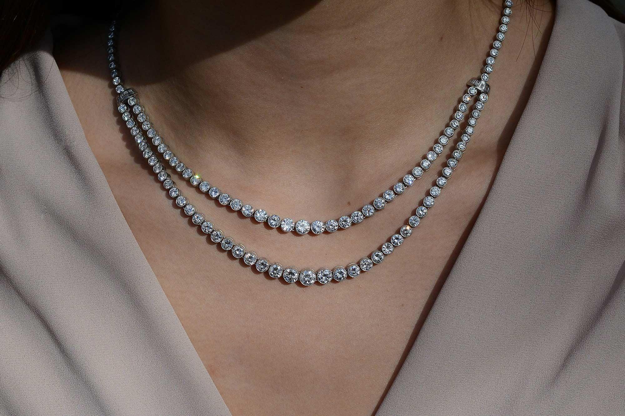 This astonishing double-strand diamond Rivière necklace certainly delivers the wow factor. Carrying a monumental 22.94 carats of diamonds individually stationed in a bezel setting extensively detailed with a delicately milgrained rim. Every diamond
