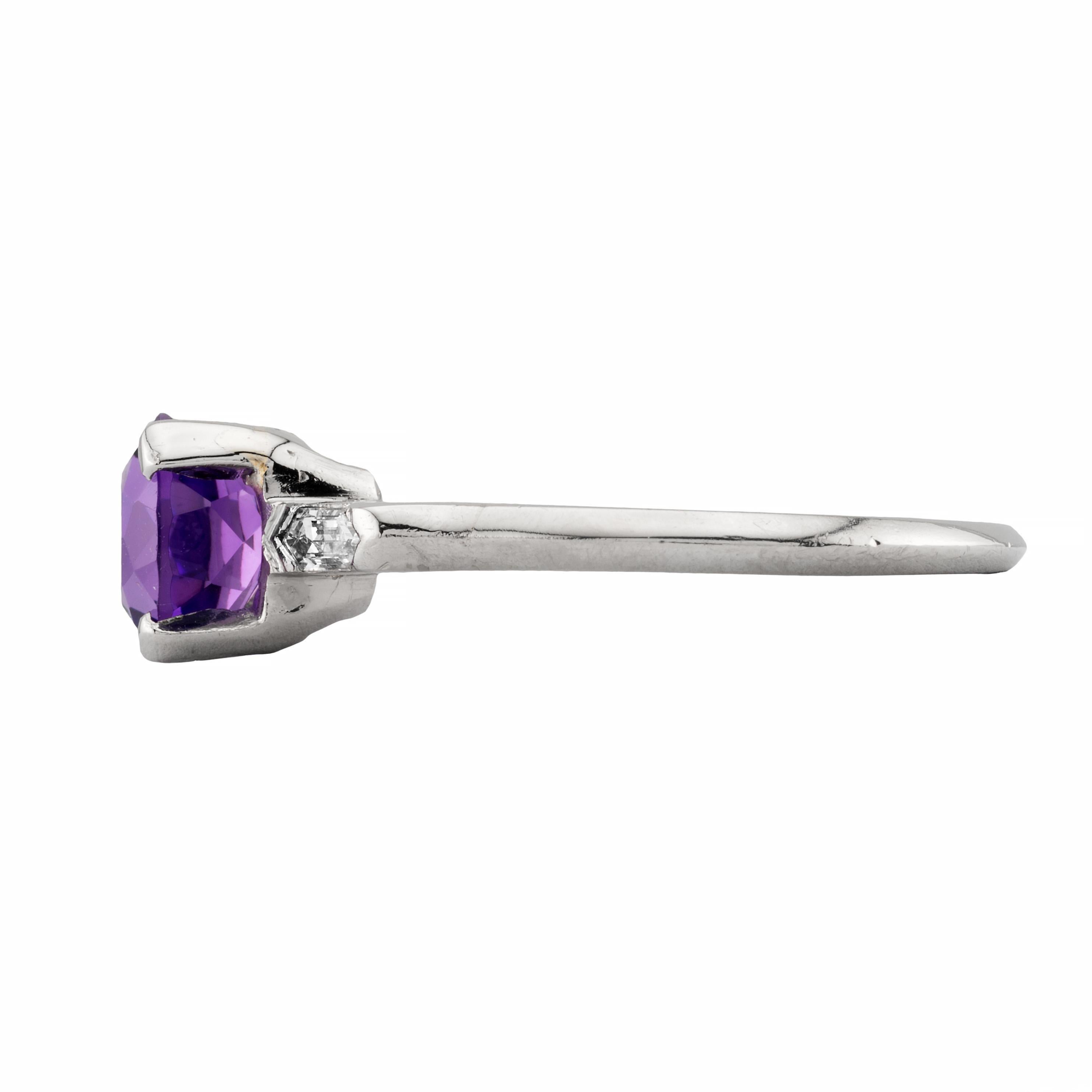 Aston Estate Jewelers Presents:

A rich royal purple amethyst, and bullet cut diamond three stone ring in platinum.  Centered by a 2.12 carat round amethyst and framed by fancy double tipped bullet shaped diamonds.  The diamonds are of 0.20ctw with