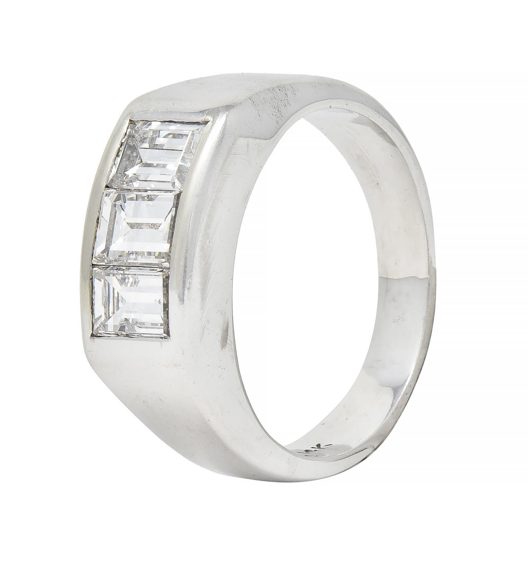 Centering three baguette cut diamonds weighing approximately 2.42 carats total 
F/G color with VS clarity - channel set to front
With high polished rectangular surround 
Stamped for 14 karat gold
Circa: 1950s
Ring size: 8 and sizable 
Measures north