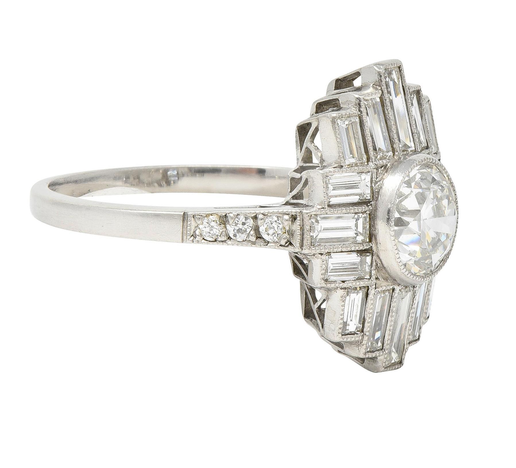Centering an old European cut diamond weighing approximately 0.99 carat - G color with VS2 clarity
Set in a milgrain bezel with a recessed streamline motif surround of clustered diamonds 
Baguette cut and weighing approximately 1.40 carats total -