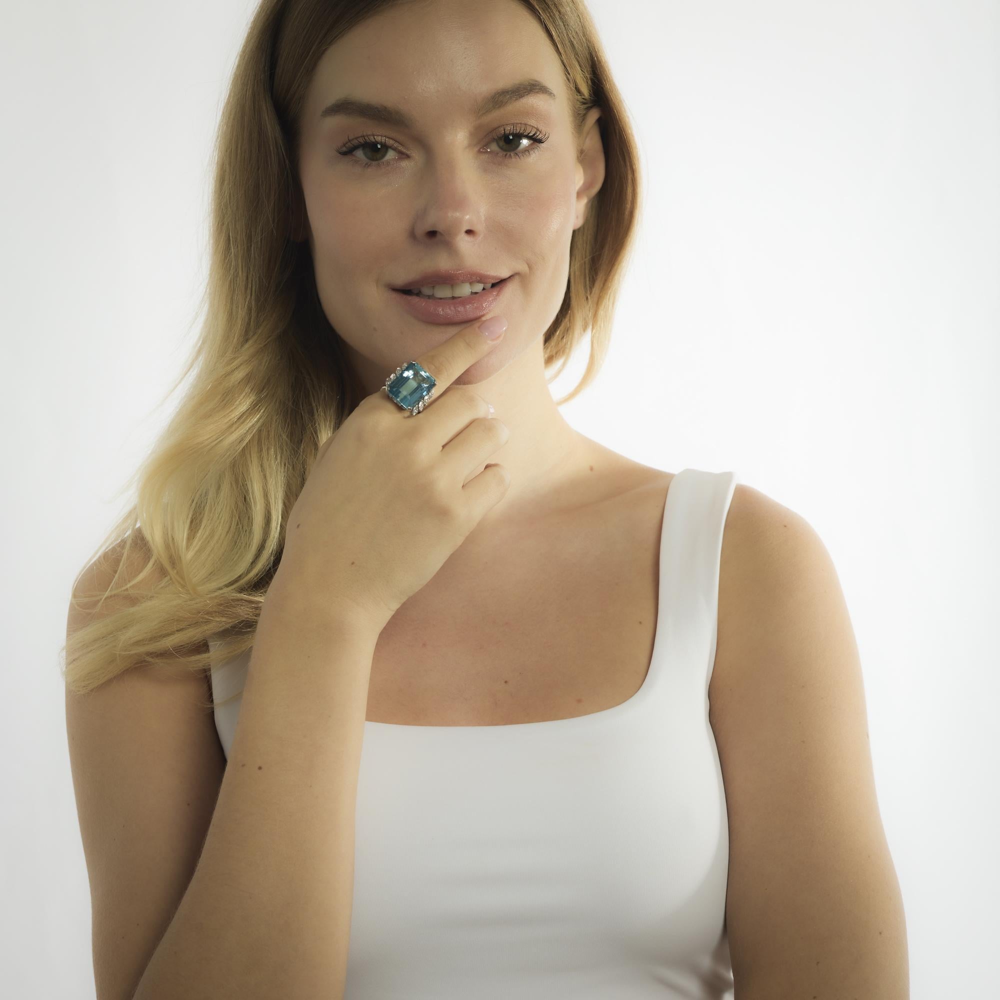 Questo anello in platino di metà secolo, risalente agli anni Cinquanta, mette in mostra un'acquamarina di 25,75 carati con taglio a smeraldo, la cui fresca tonalità blu è completata dall'elegante geometria dell'incastonatura. Otto diamanti taglio