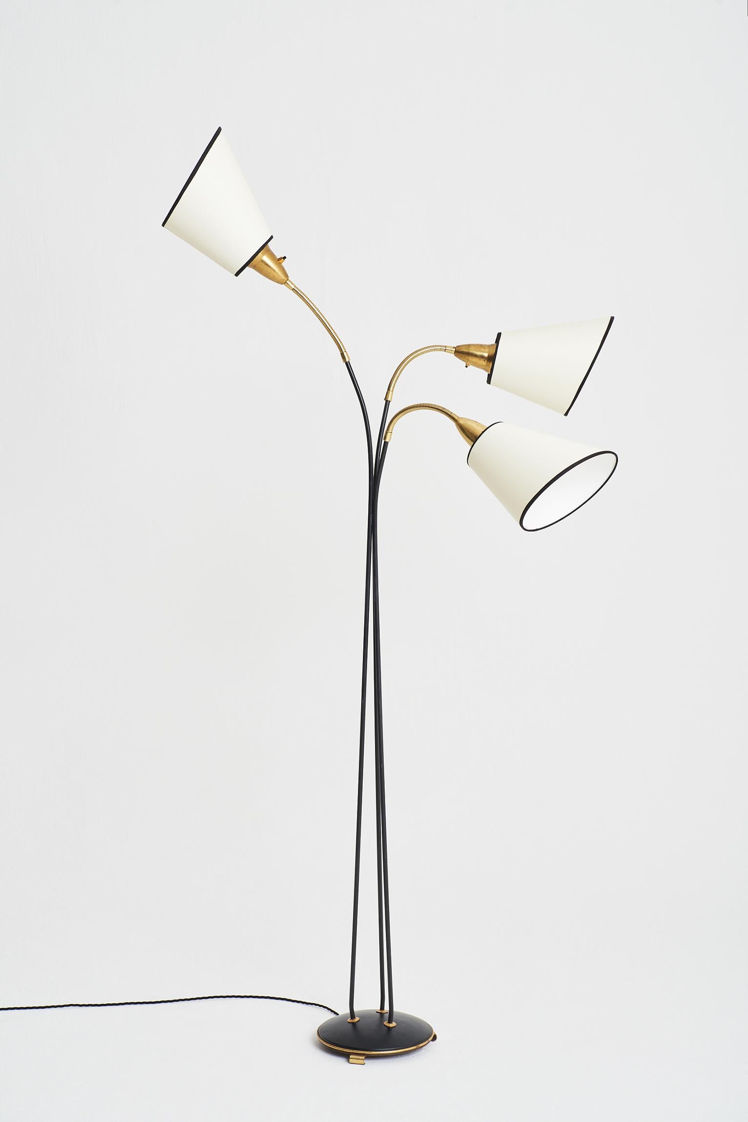 A black enamelled iron and brass three-arm floor lamp, with bespoke shades.
Sweden, third quarter of the 20th century.