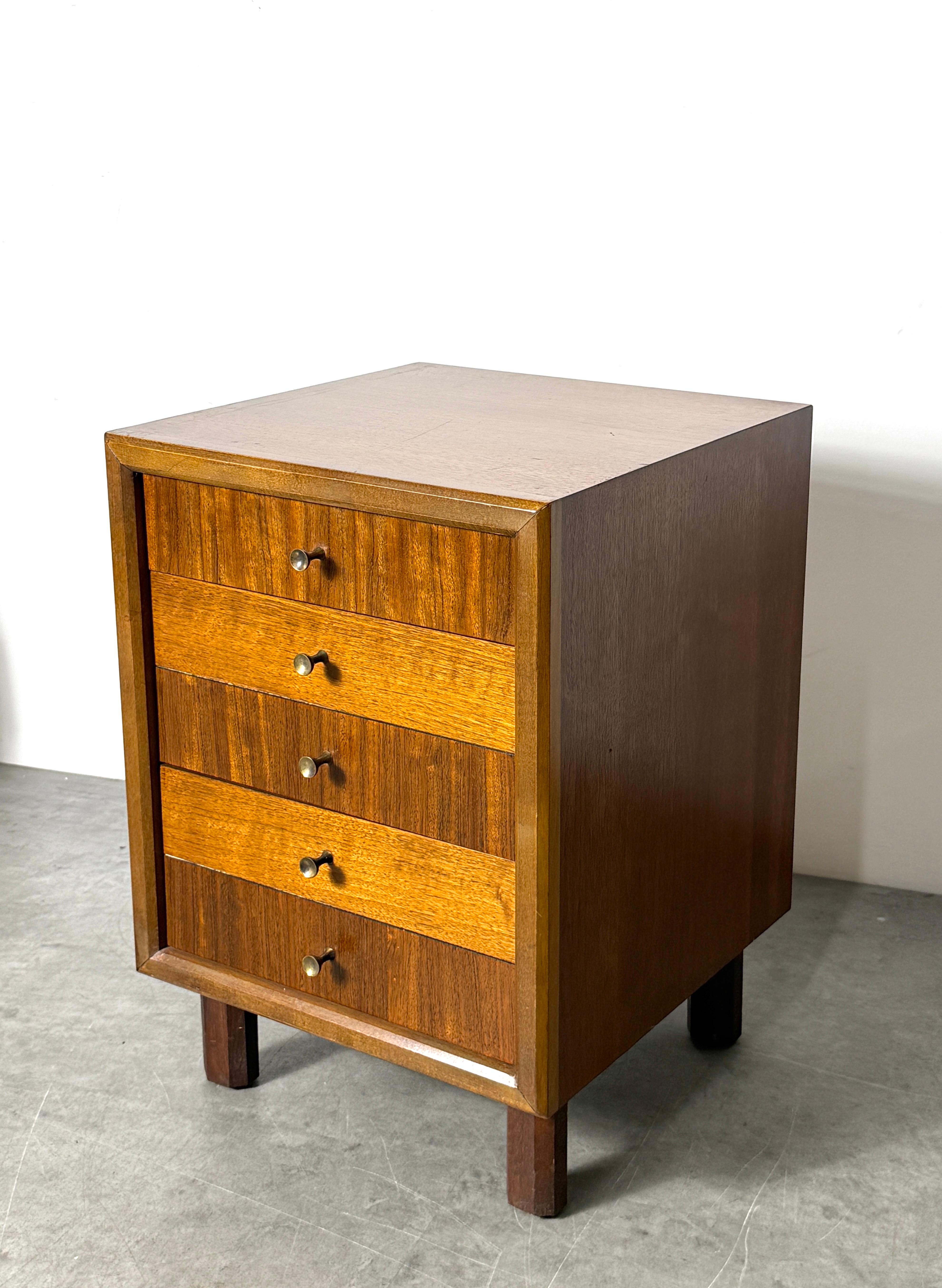 Petite table d'appoint ou commode dans le style de Harvey Probber
USA circa 1960's

Trois tiroirs en noyer avec des motifs de grain alternés sur les façades des tiroirs. 
Reposant sur des pieds en forme de poteau à facettes et finie avec des